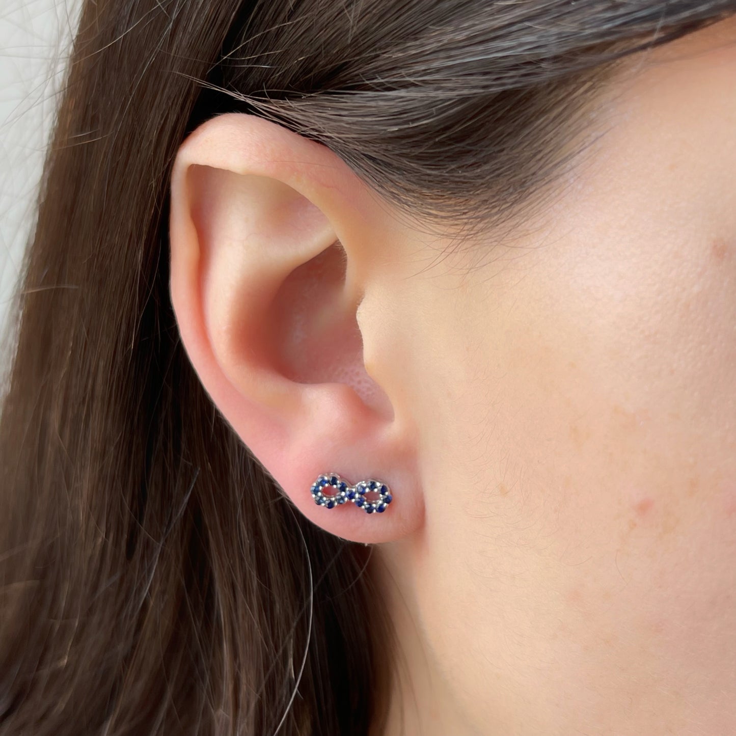 Aretes de infinito de zafiros en oro blanco 10k con broche a rosca
