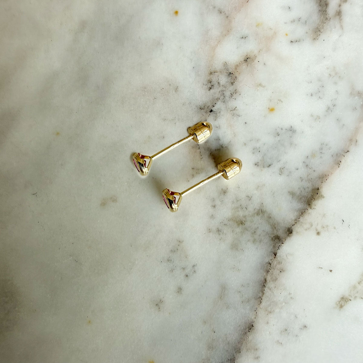 Aretes en oro amarillo 14k con circón fucsia biselado borde grueso con tope rosca