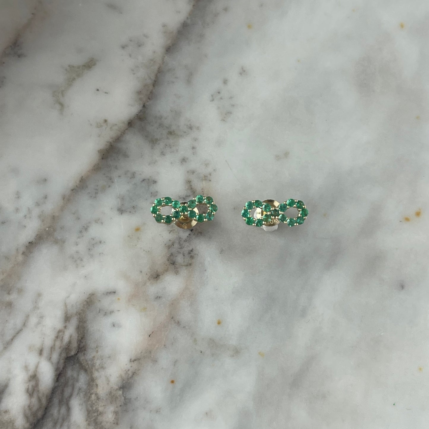 Aretes de infinito de esmeraldas en oro amarillo 10k con broche a rosca