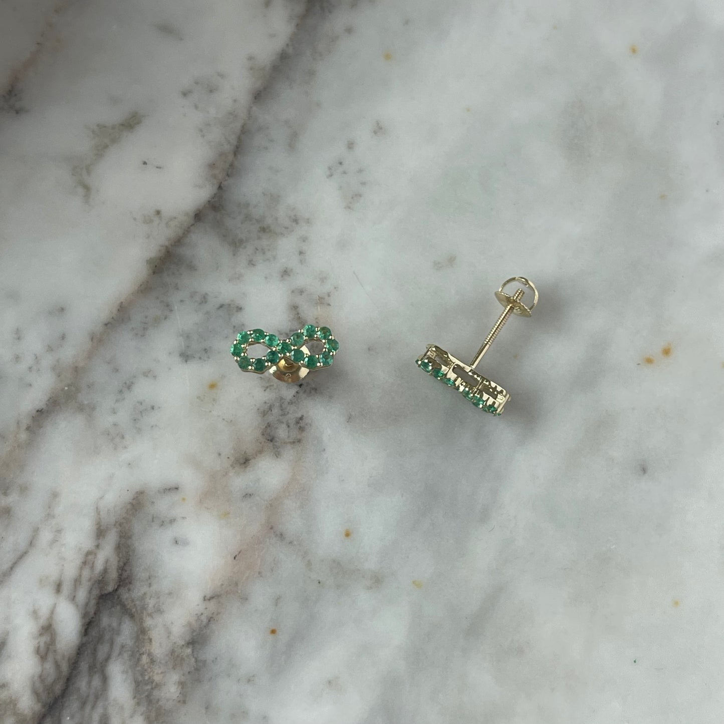 Aretes de infinito de esmeraldas en oro amarillo 10k con broche a rosca