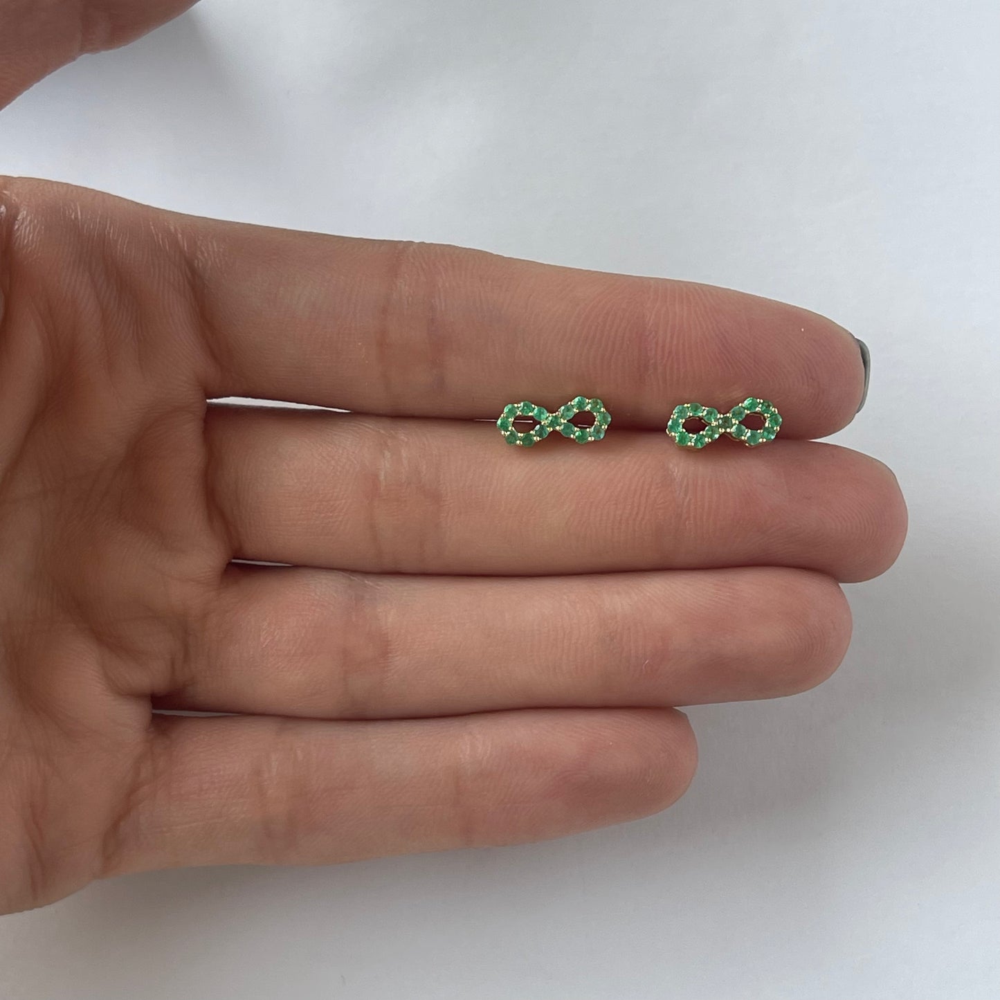 Aretes de infinito de esmeraldas en oro amarillo 10k con broche a rosca