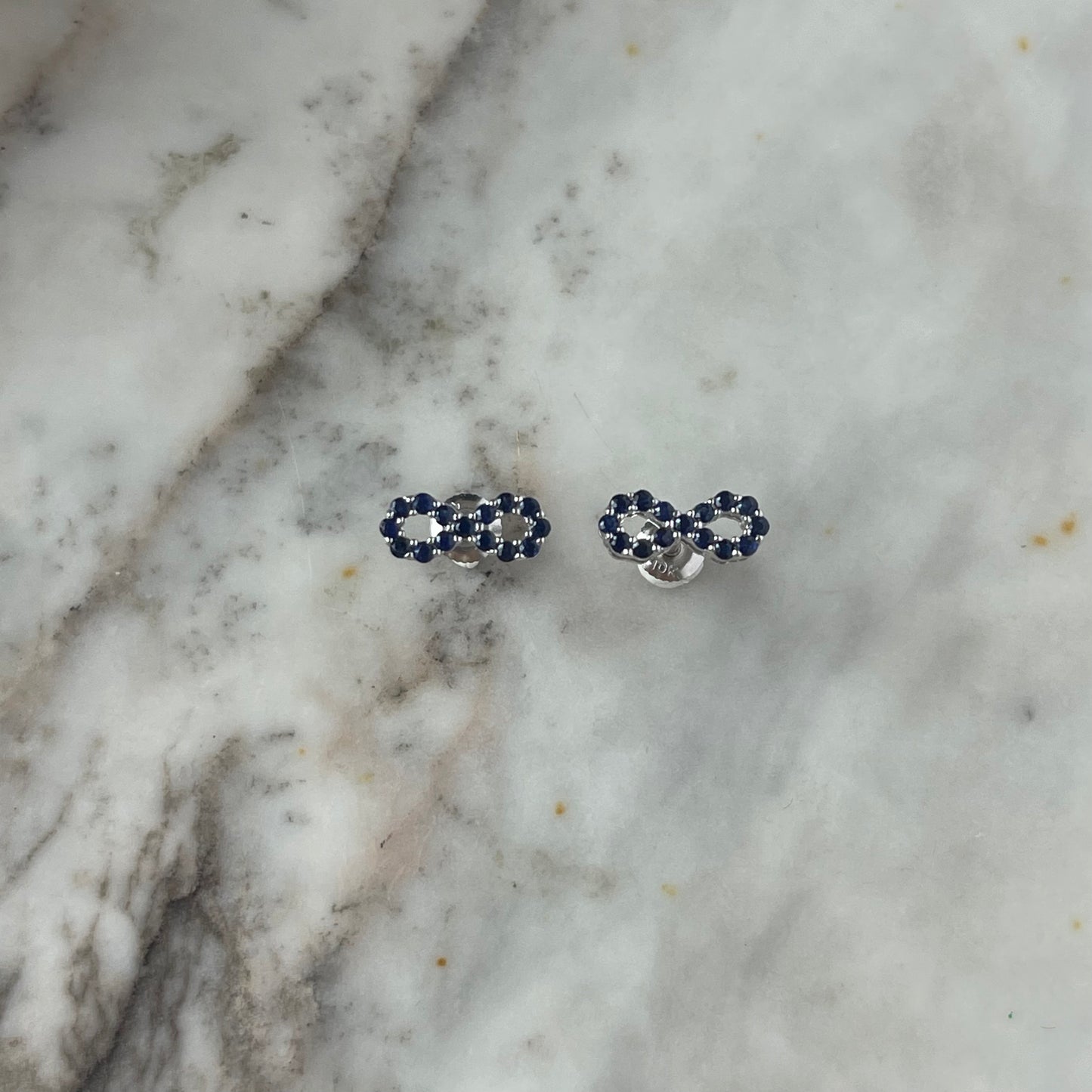 Aretes de infinito de zafiros en oro blanco 10k con broche a rosca