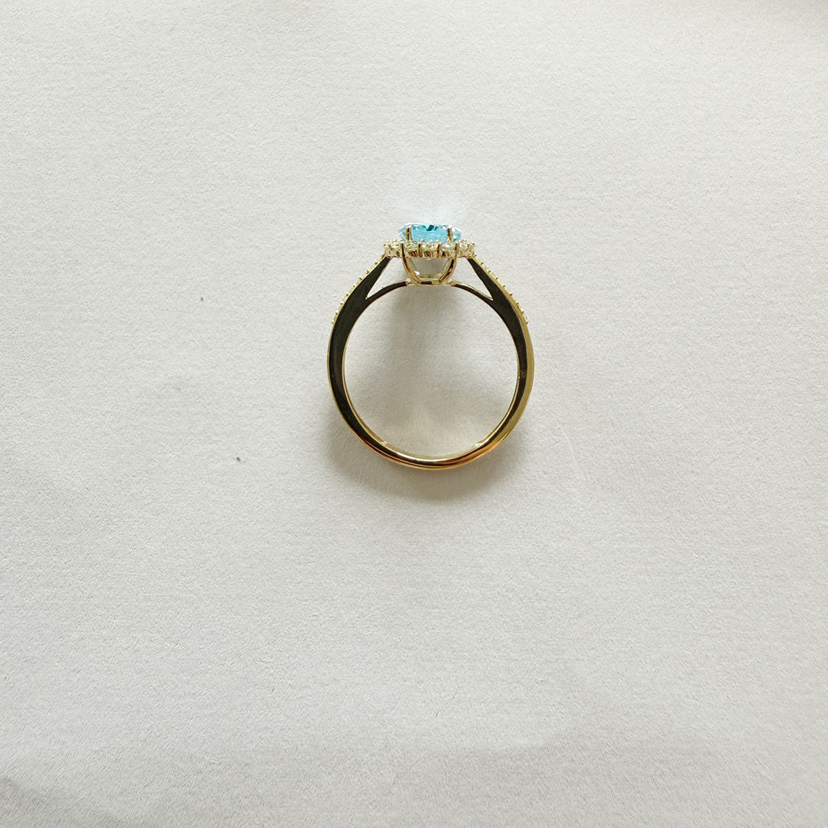Anillo en oro amarillo 10K con topacio azul ovalado y halo de diamantes 0.35ctw