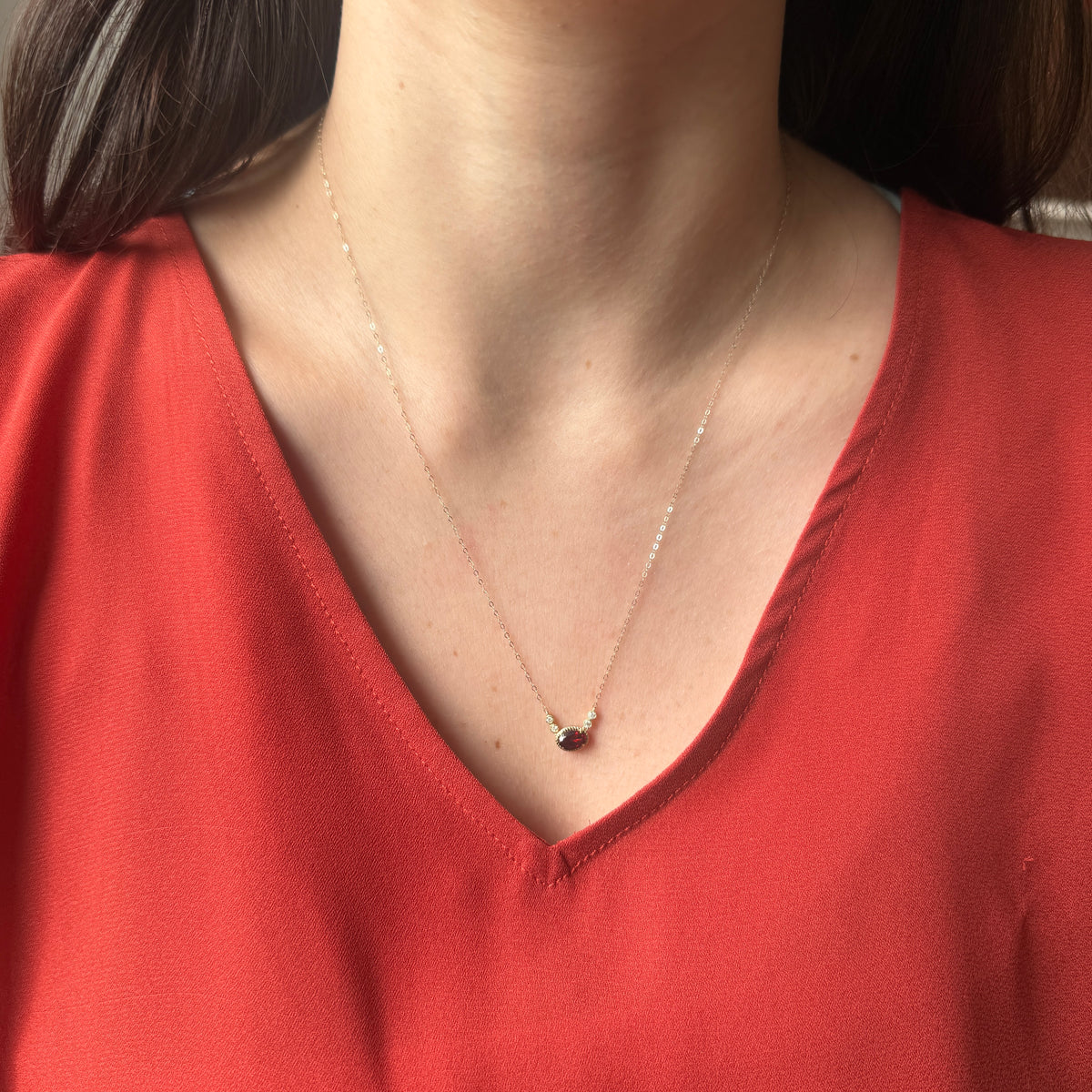 Collar en oro amarillo 10K con granate ovalado y diamantes 0.08ctw
