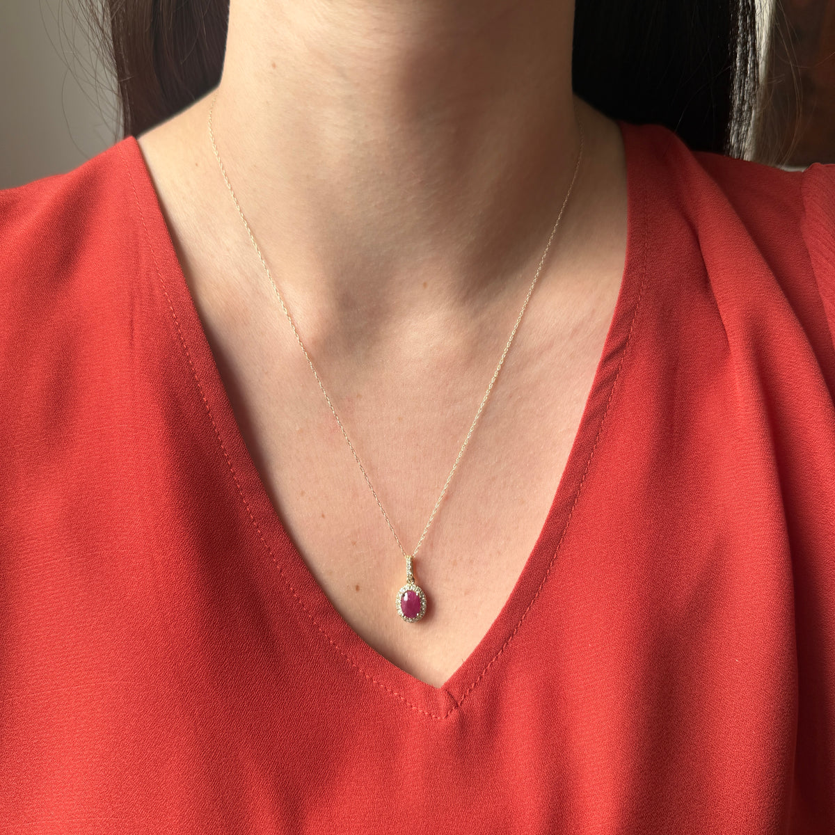 Collar en oro amarillo 10K con dije de rubí ovalado con halo y pasa cadenas de diamantes 0.30ctw