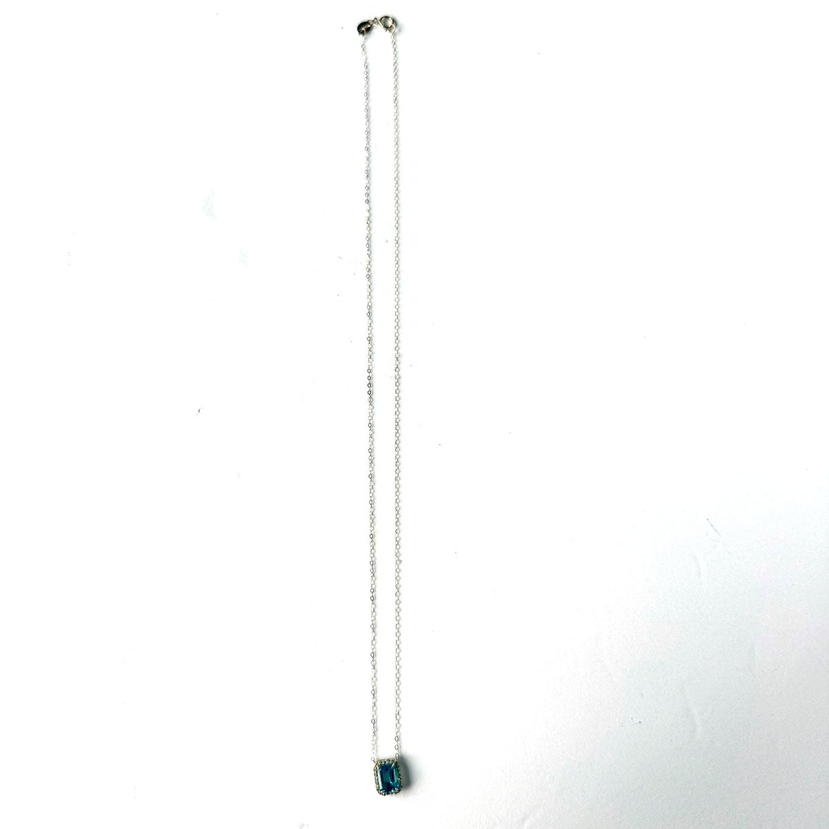 Collar en oro amarillo 10K con topacio azul y halo de diamantes 0.11ctw
