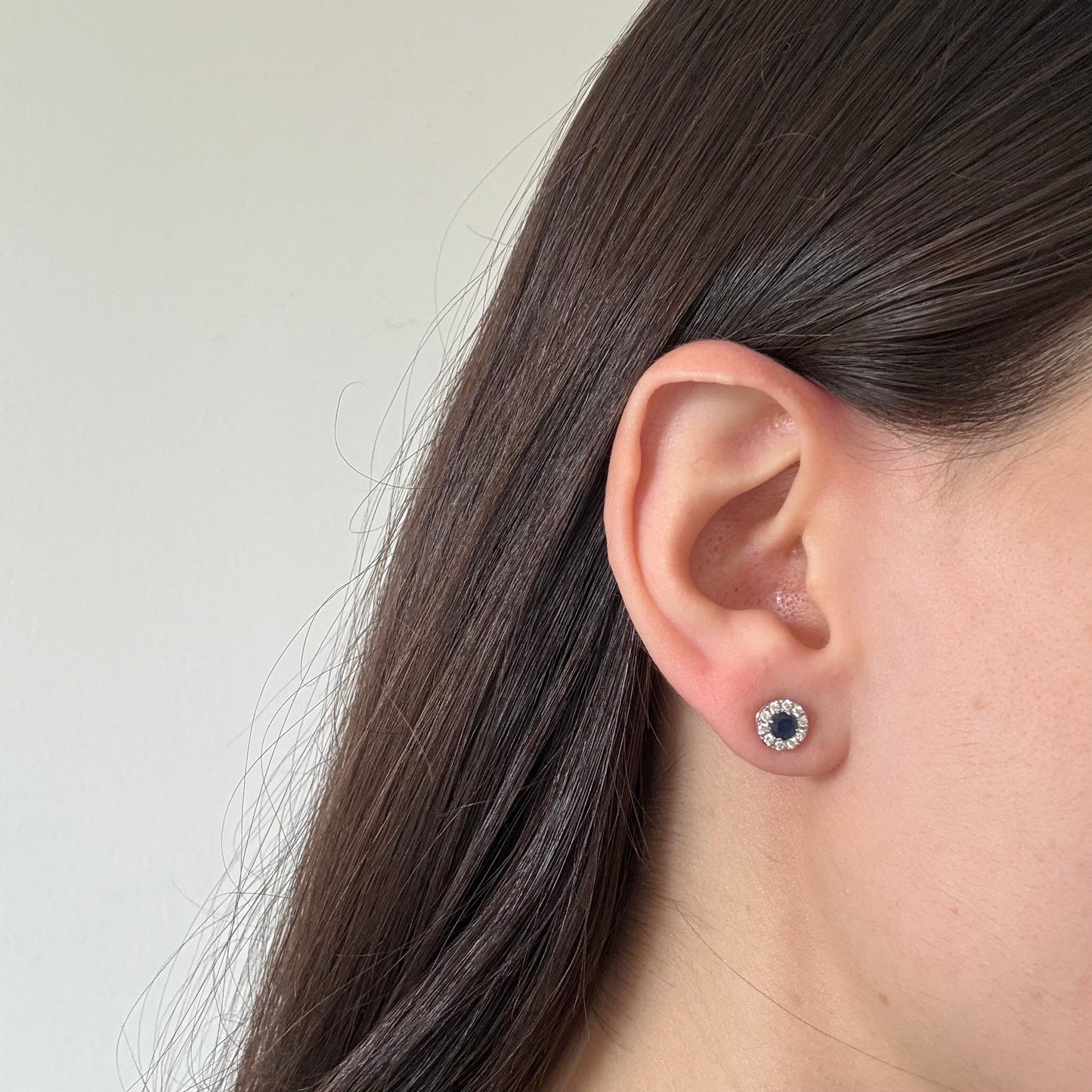 Aretes en oro blanco 14K con zafiro redondo y halo de diamantes 0.20ctw