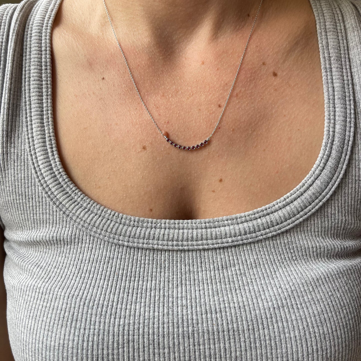 Collar en oro blanco 10k con curva de rubíes biselados