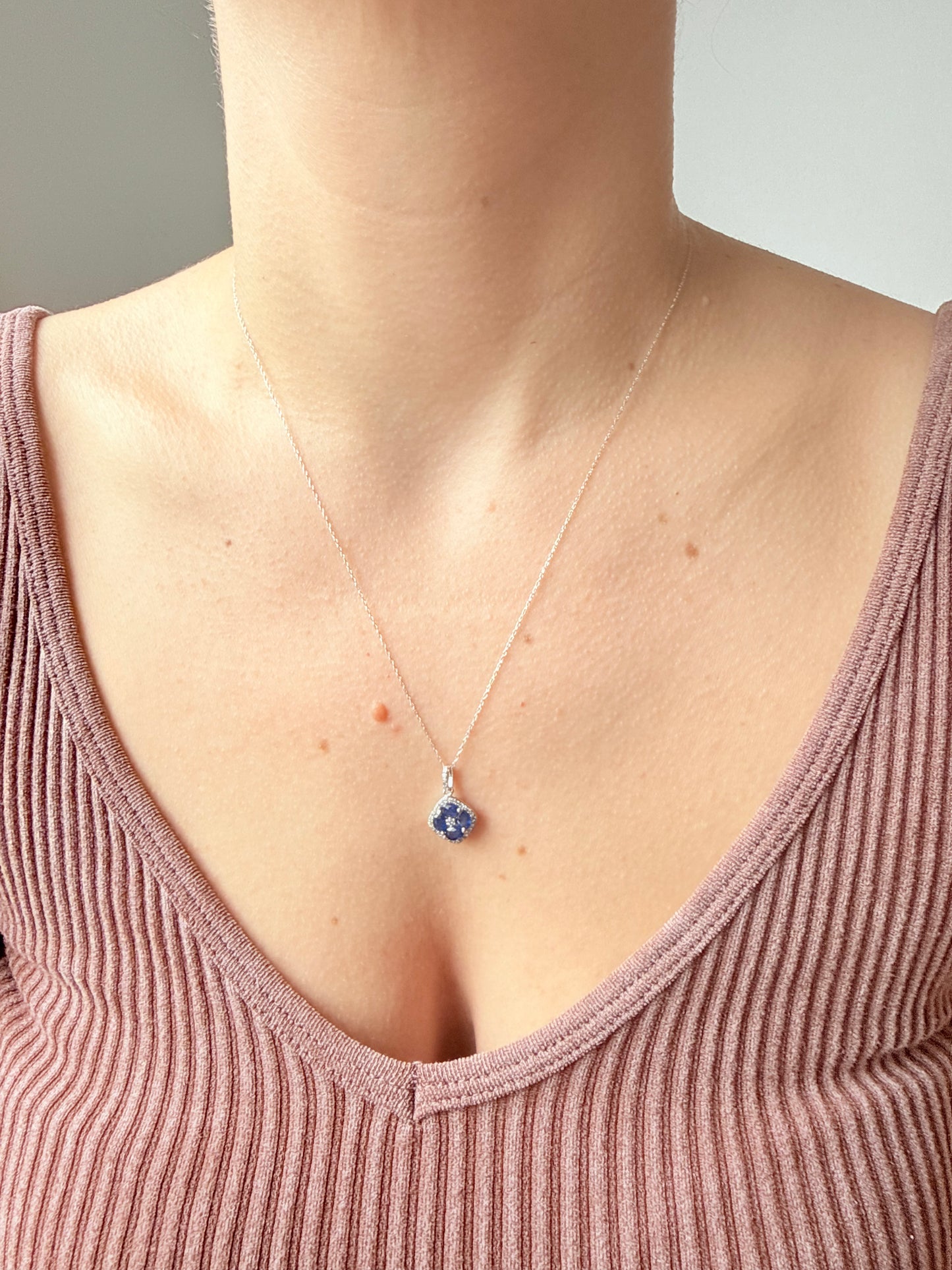 Collar en oro blanco 14k con dije de zafiros en forma de flor y borde de diamantes 0.15ctw