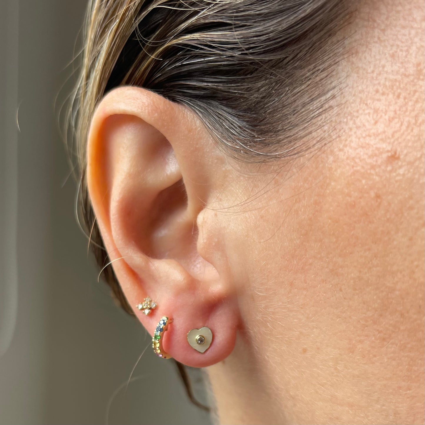Aretes en oro amarillo 14 K con corazón de madre perla y circonita en el centro con tope rosca