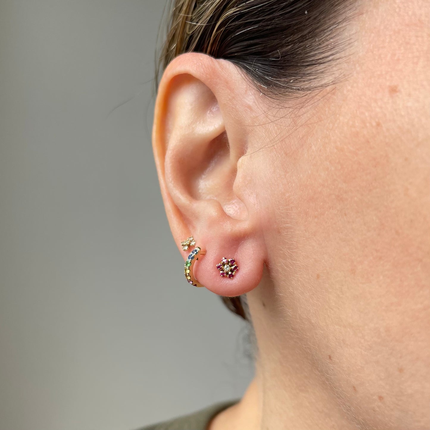 Aretes en oro amarillo 14k con flor de circonitas fucsia de 6 petalos