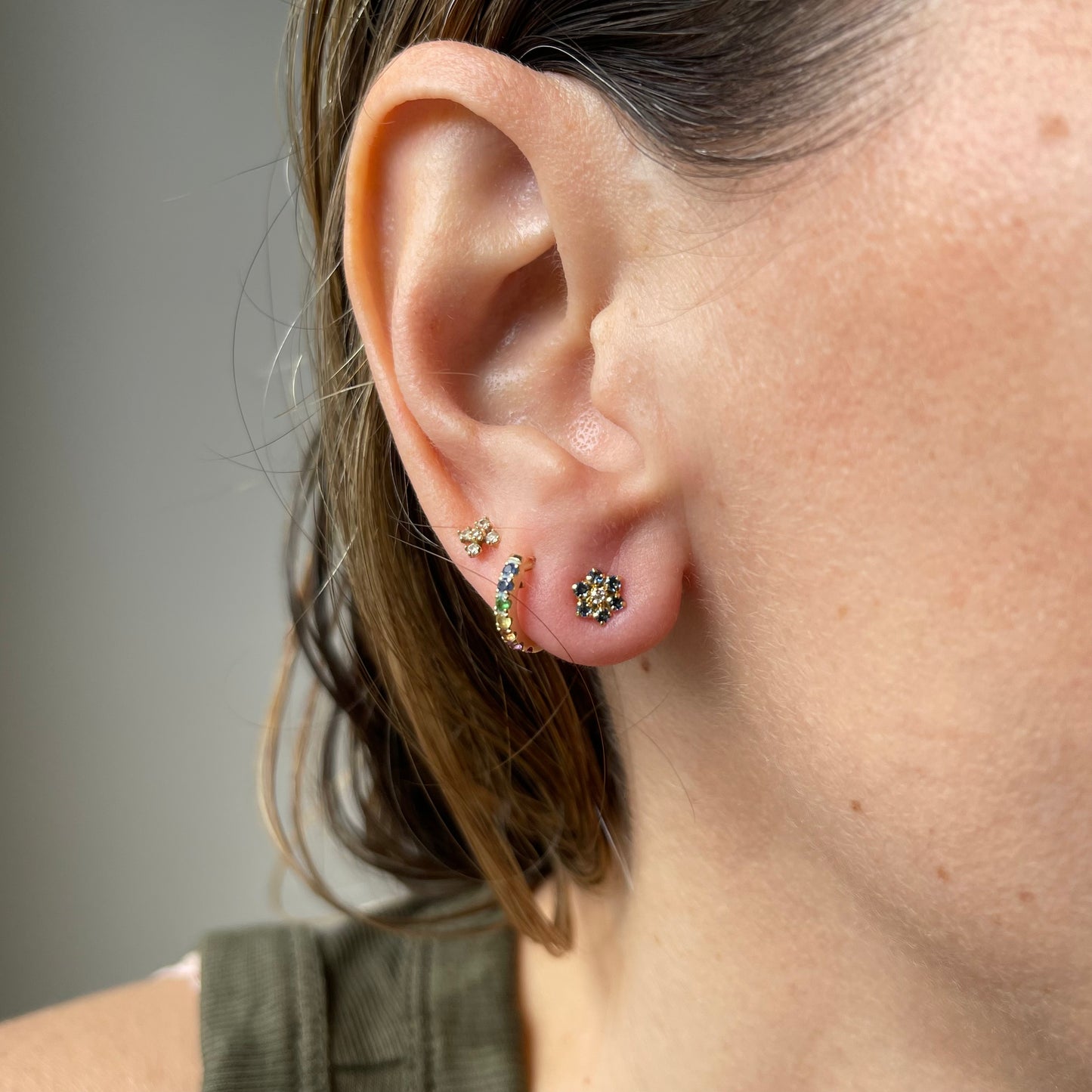Aretes en oro amarillo 14k con flor de circonitas celestes de 6 petalos