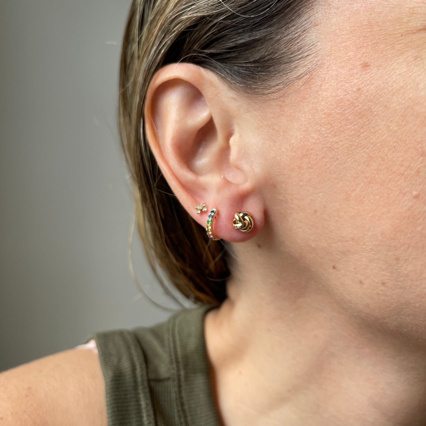 Aretes en oro amarillo 14k con nudo de aros redondeados y tope tornillo
