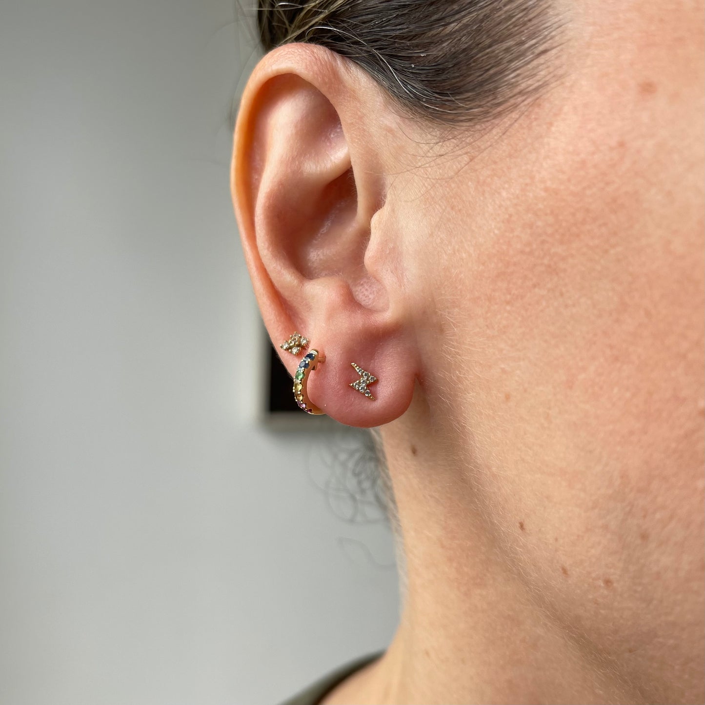 Aretes en oro amarillo 14k en forma de rayo con circonitas y tope tornillo