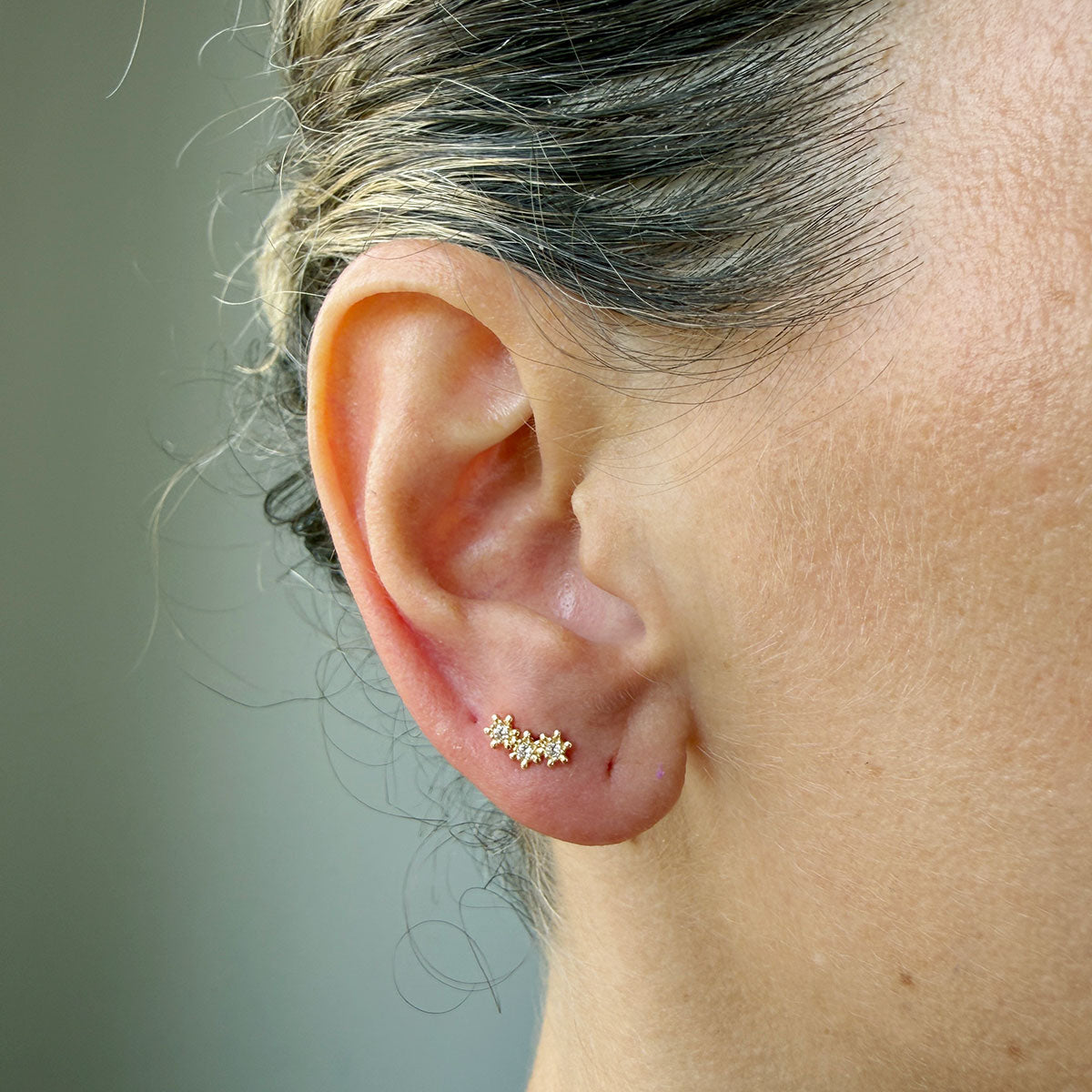 Arete en oro amarillo 14k con tres estrellas de circonitas blancas