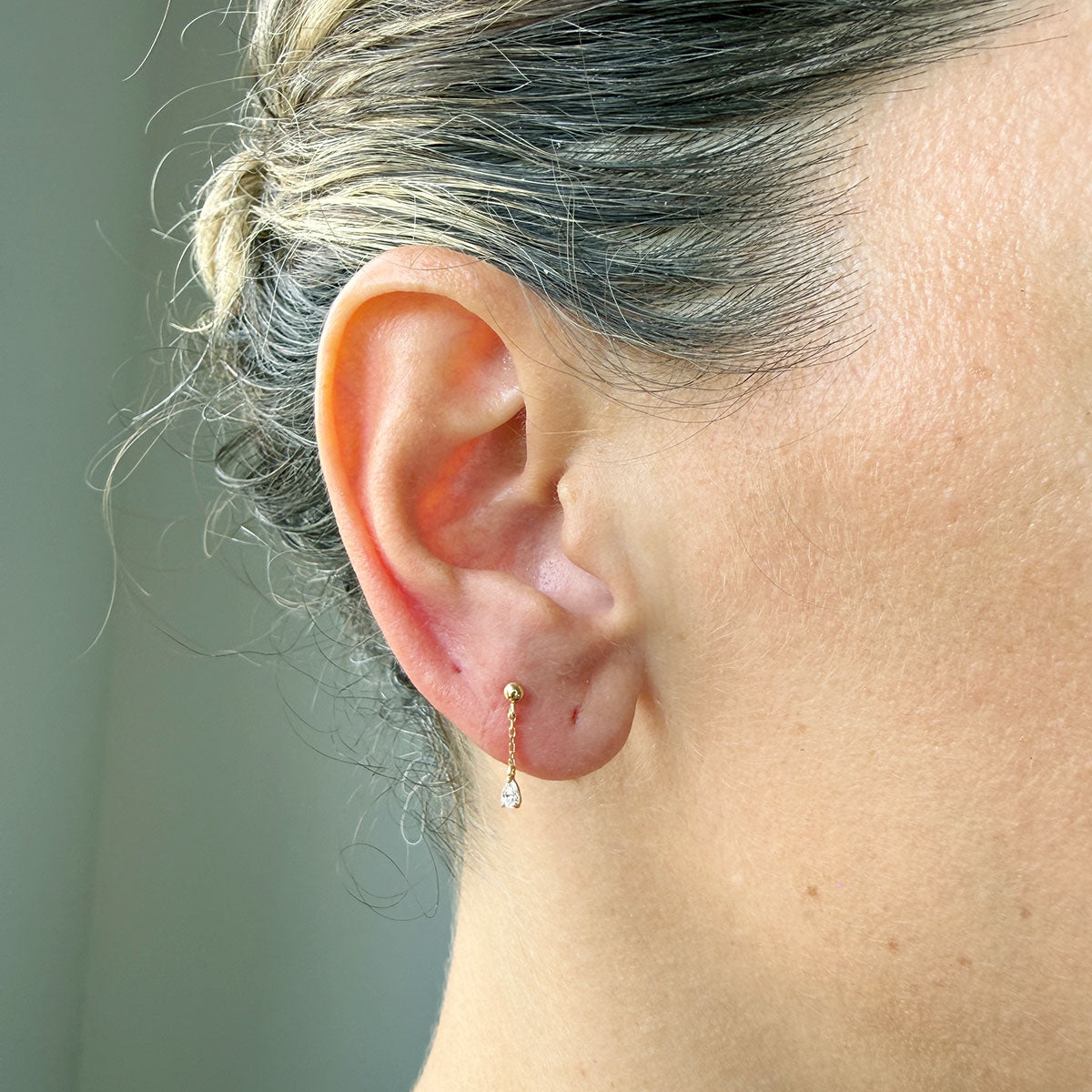 Arete piercing bolita de oro amarillo 14k con cadena y gota de circón colgando