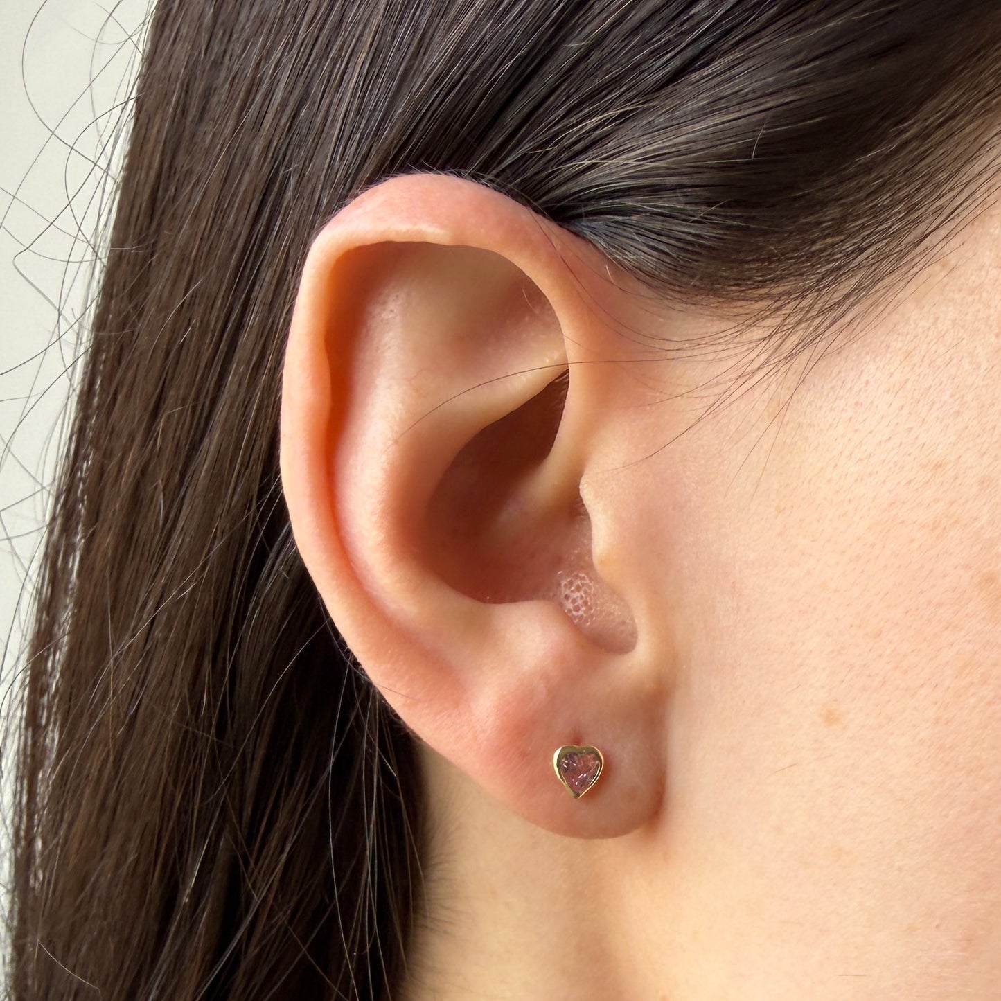 Aretes en oro amarillo 14k con corazón de circonita rosada biselado con tope rosca