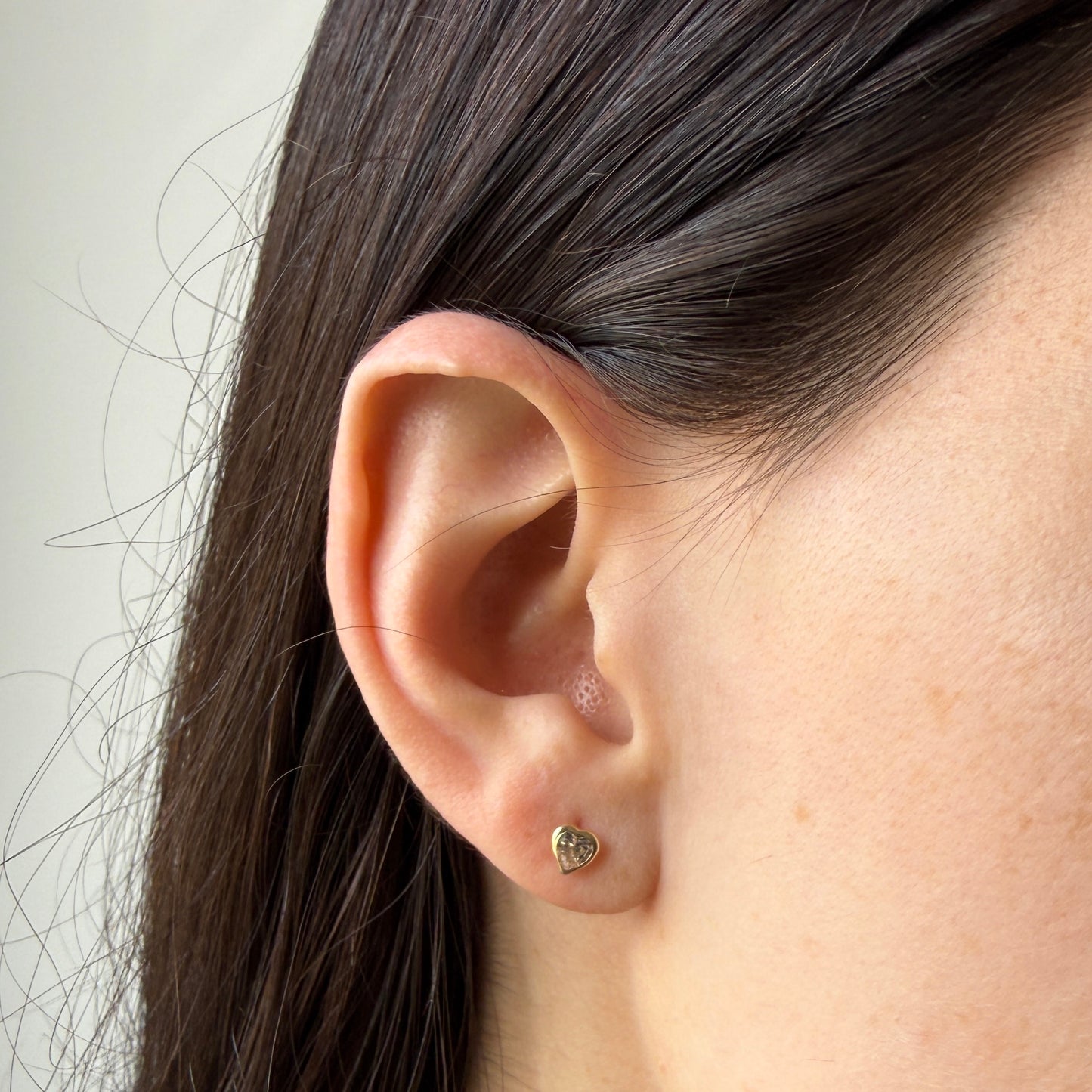 Aretes en oro amarillo 14k con corazón de circonita transparente biselado con tope rosca
