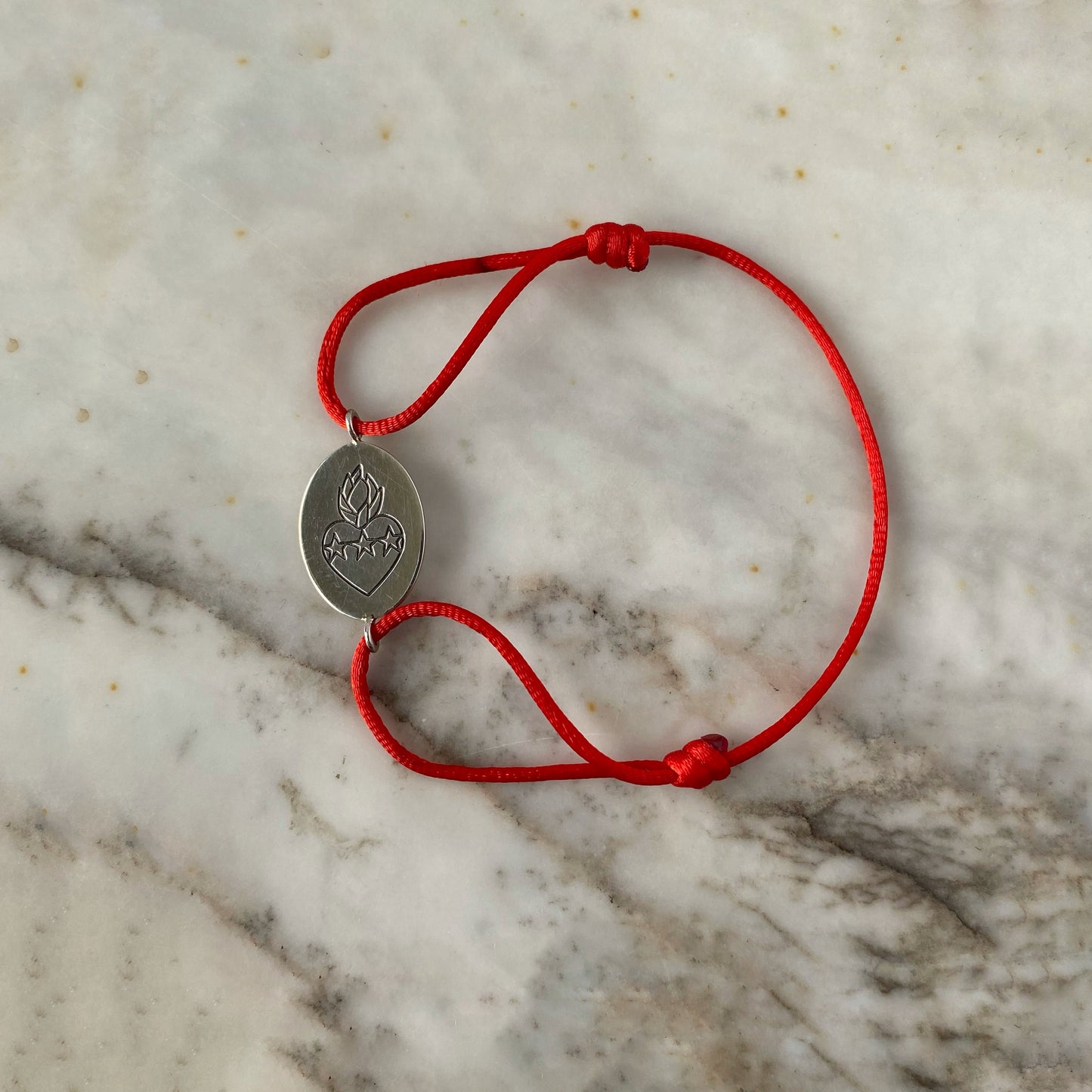 Pulsera de cordón con escapulario ovalado en plata