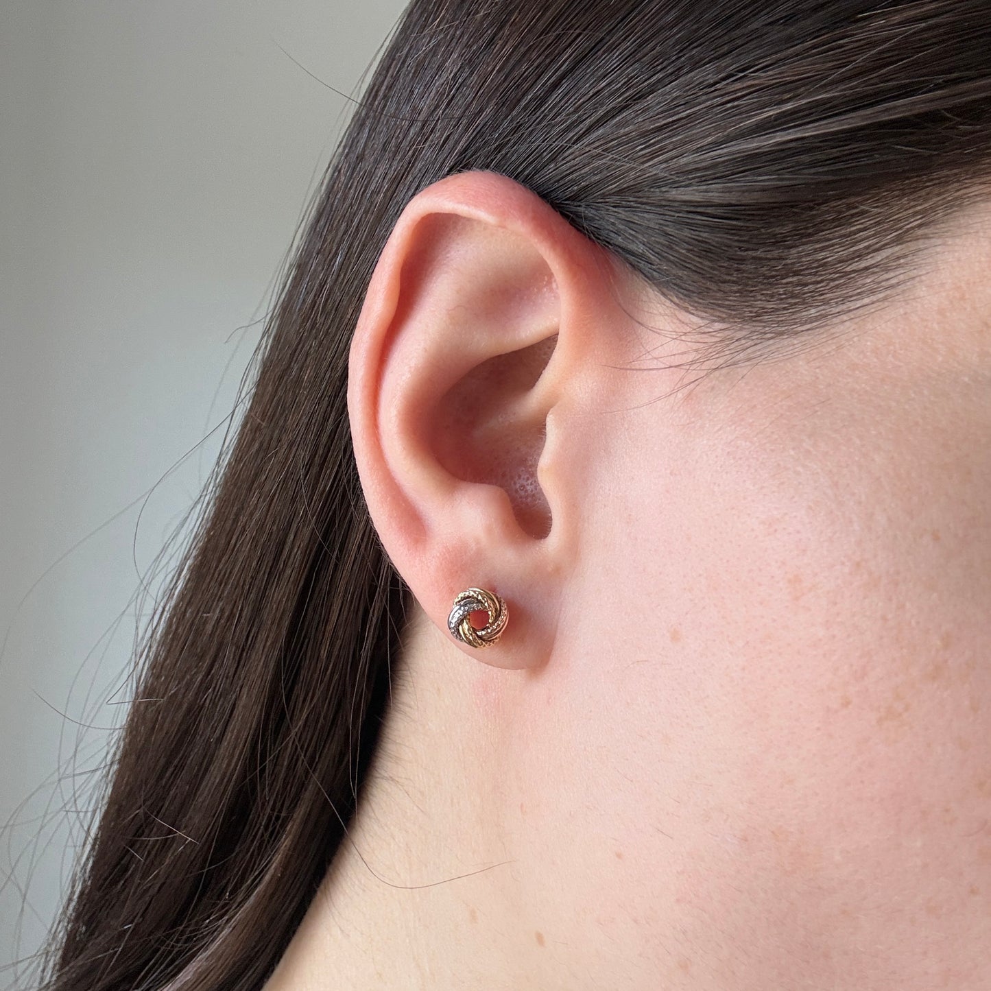 Aretes nudo en tres oros 18k con textura y tope rosca