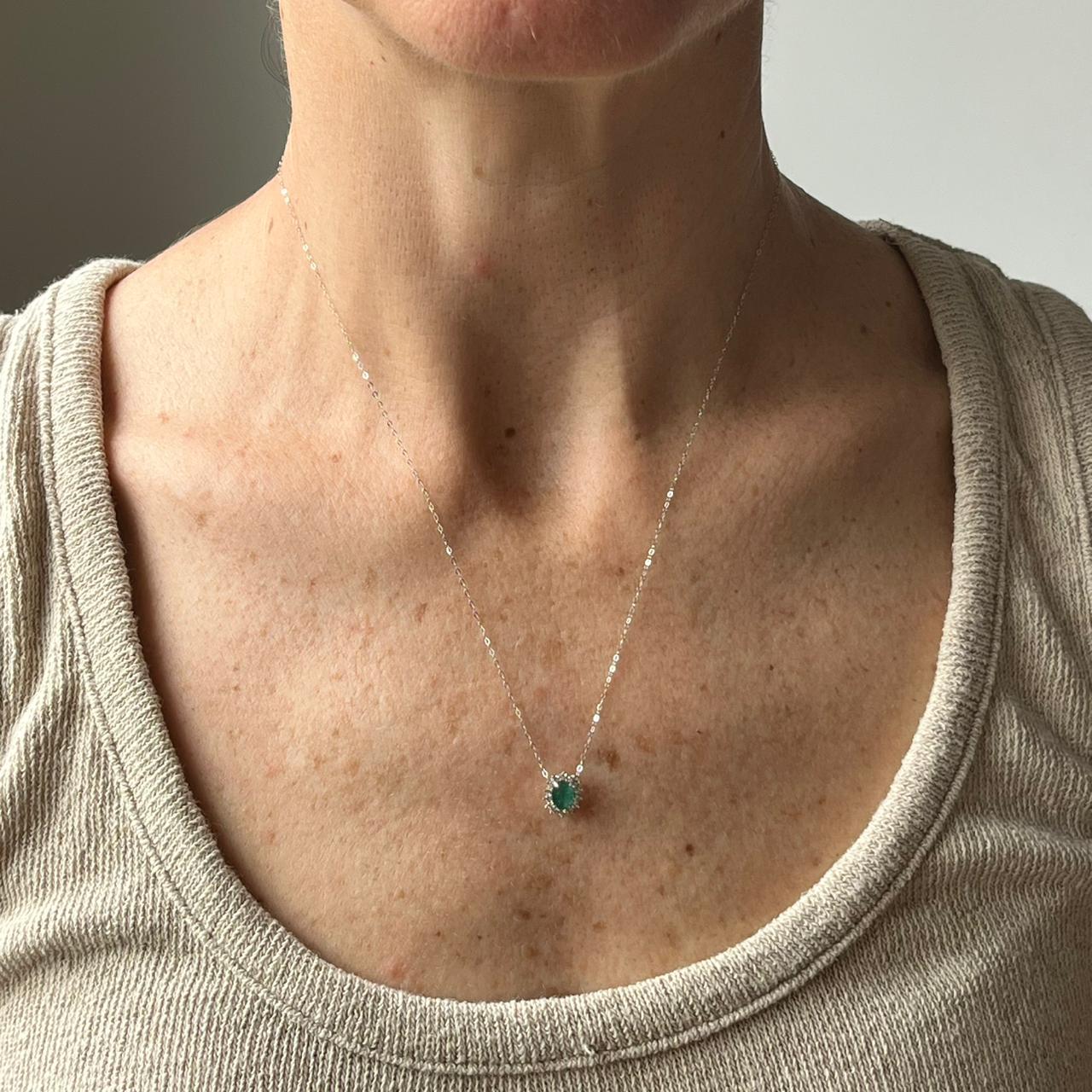 Collar en oro blanco 14K con esmeralda ovalada y halo de diamantes 0.20ctw