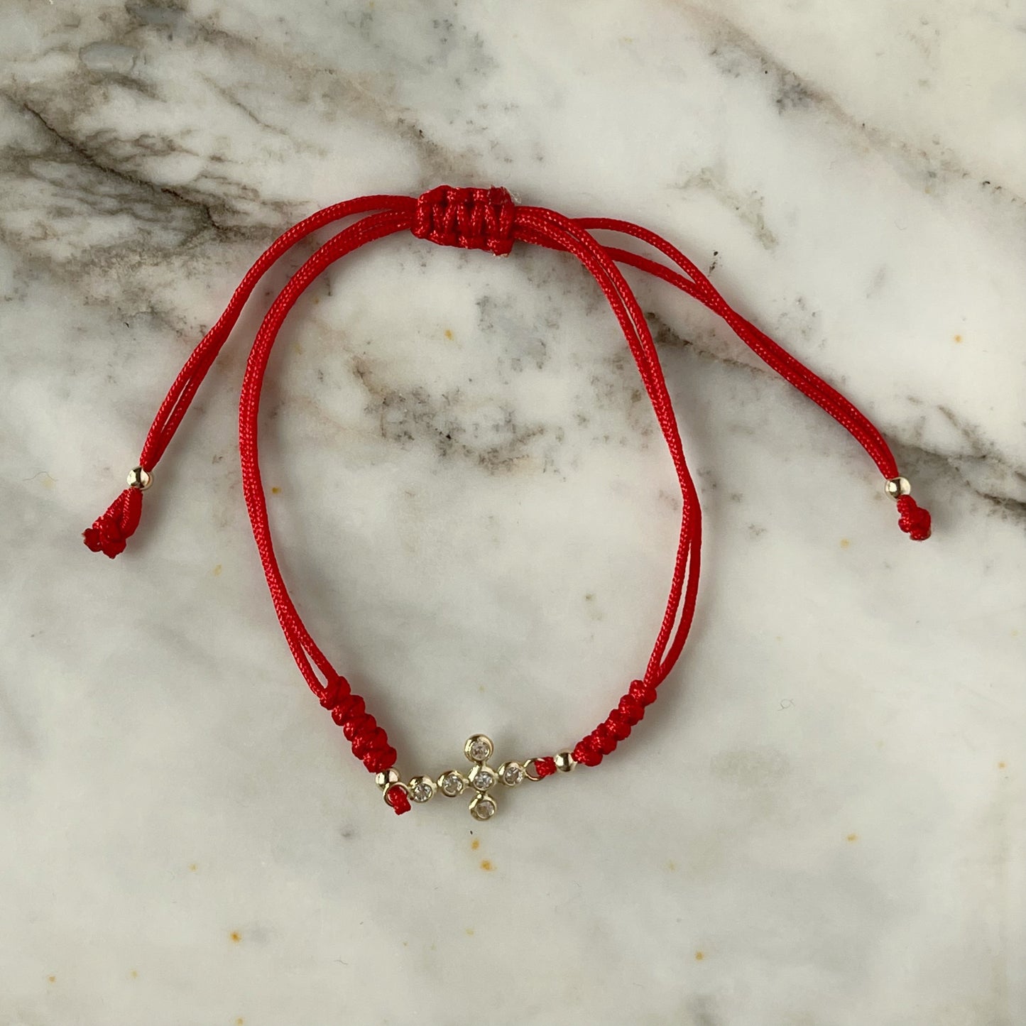 Pulsera cordón rojo cruz en oro de 14K