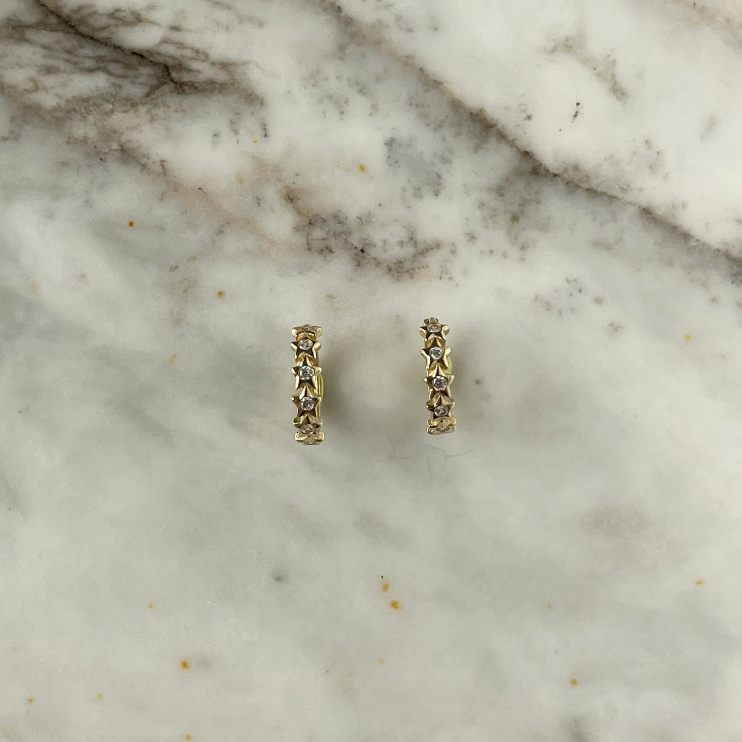 Argollas mini con circonitas blancas de estrellas en oro de 14k