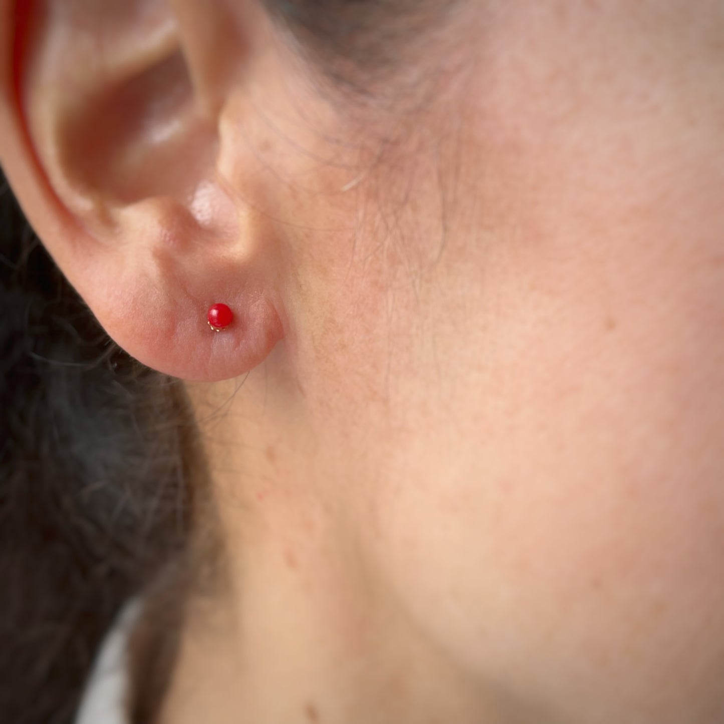 Arete bolita de coral en oro amarillo de 18k con tope ortopédico