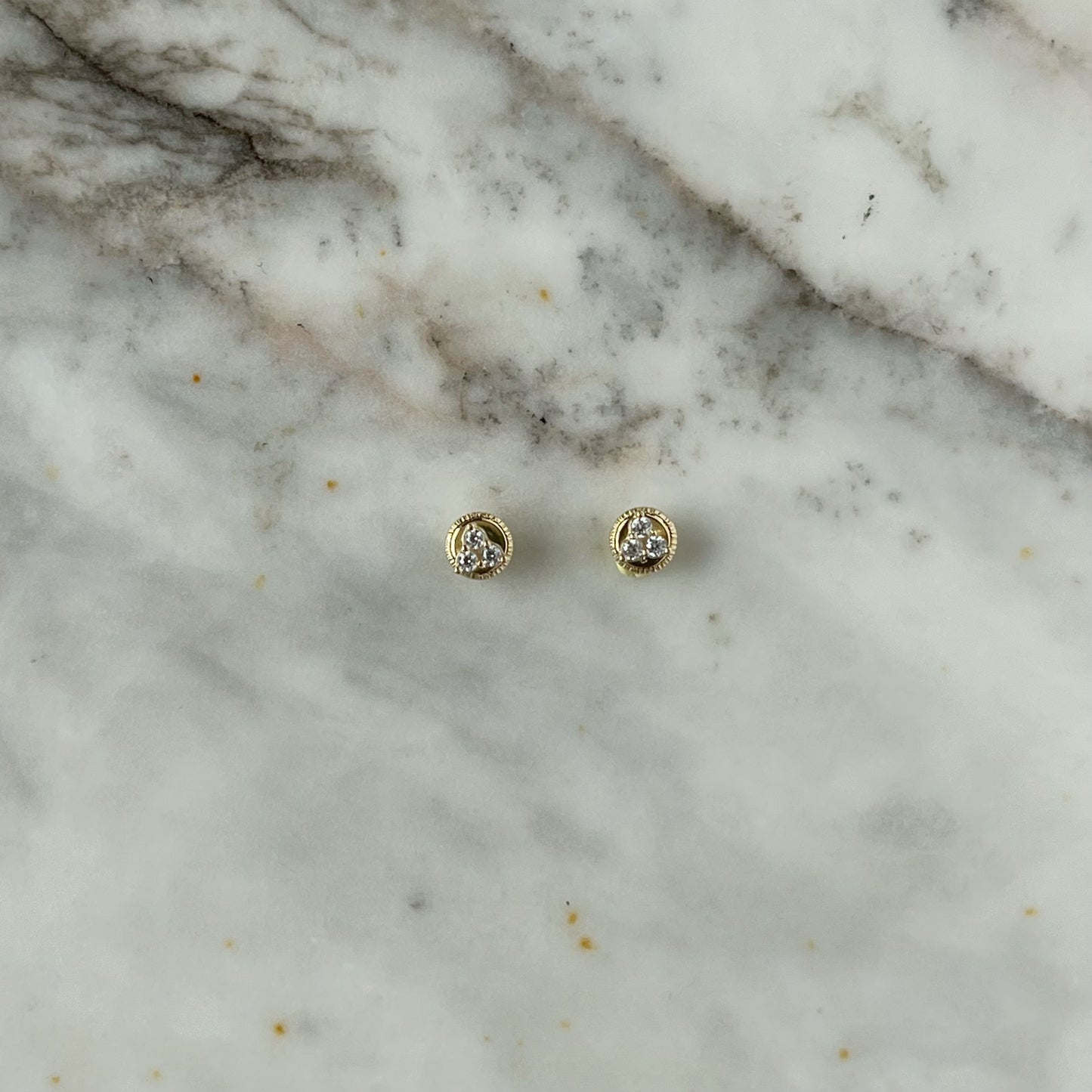 Aretes tres circonitas blancas mini en oro de 14k con tope ortopédico