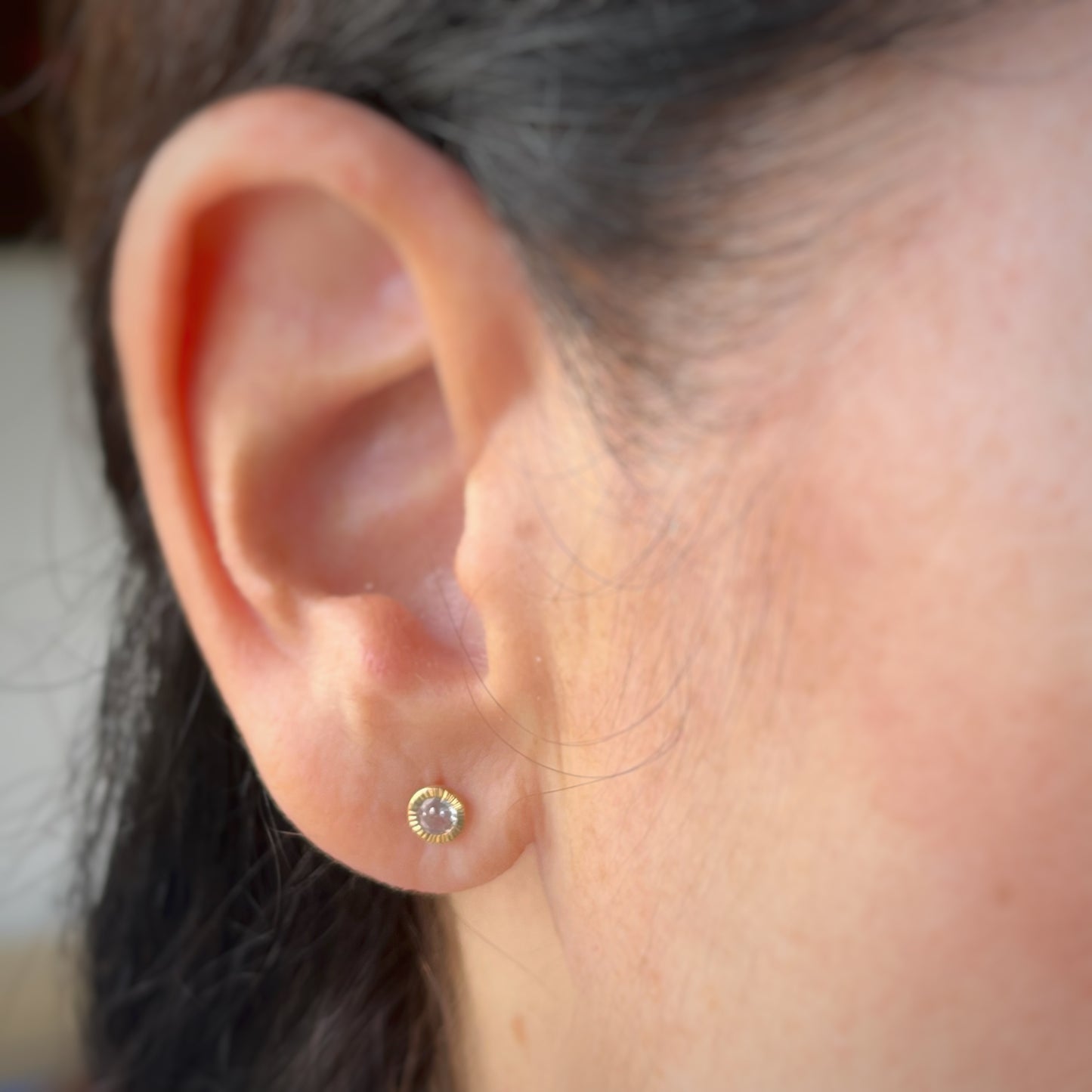 Arete con circonita biselada con aureola rayada en oro amarillo de 14k con tope ortopédico