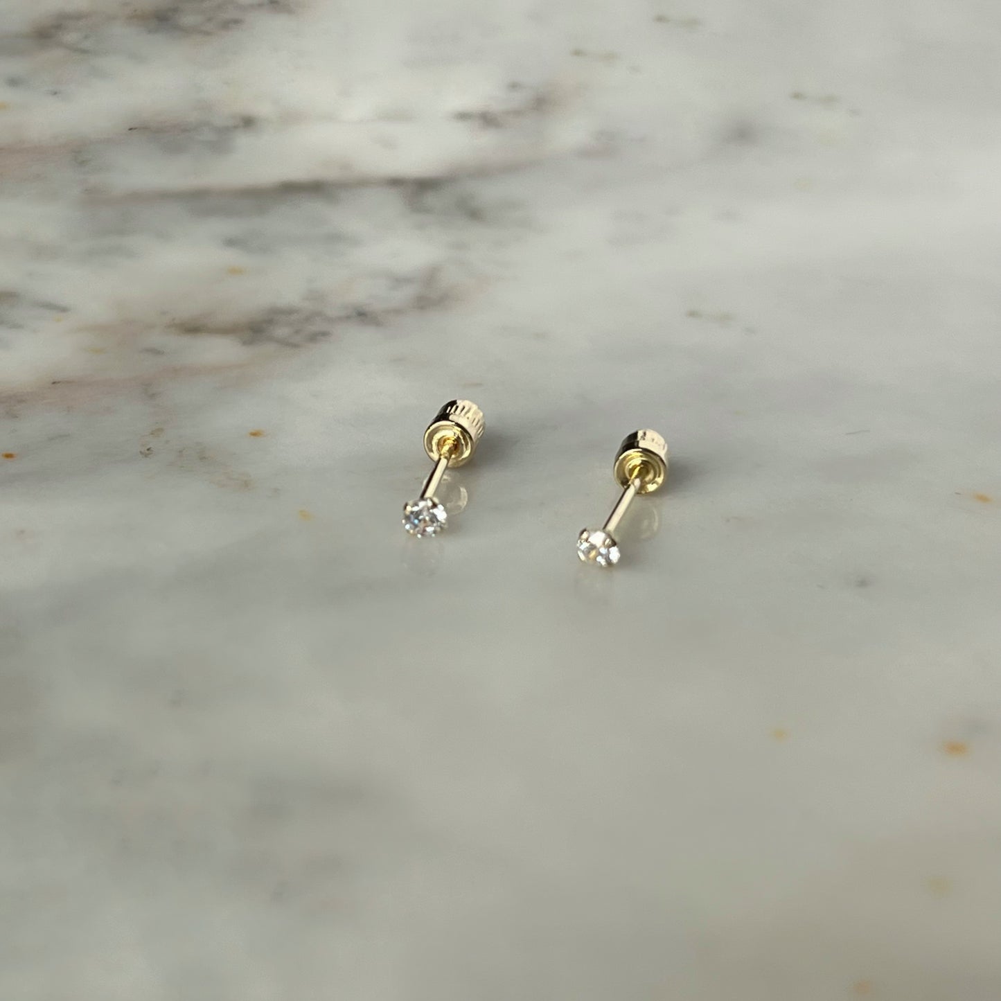 Aretes circonita blanca de 2mm en oro amarillo de 14k con tope ortopédico