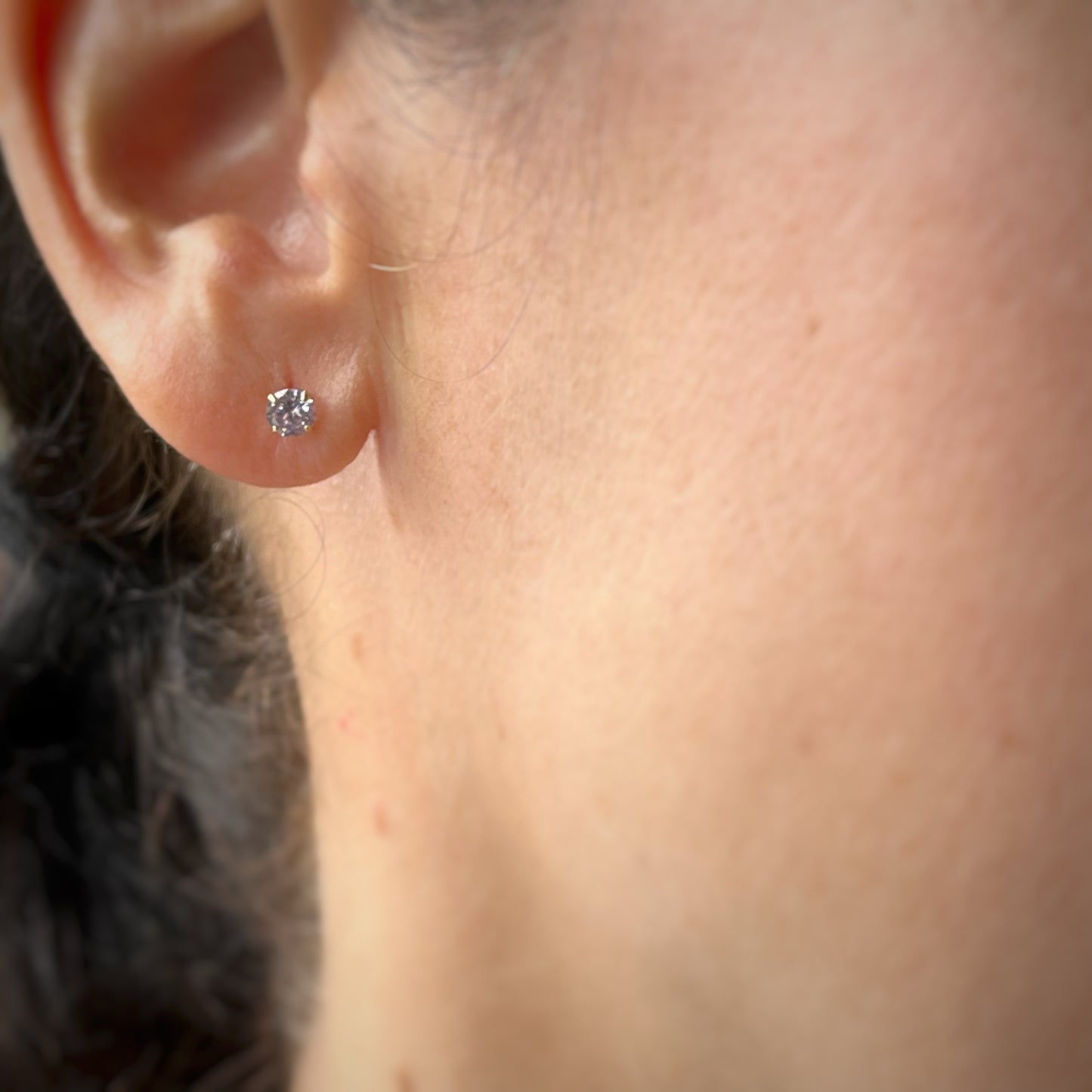 Arete con circonita redonda lila en oro amarillo de 14k con tope ortopédico