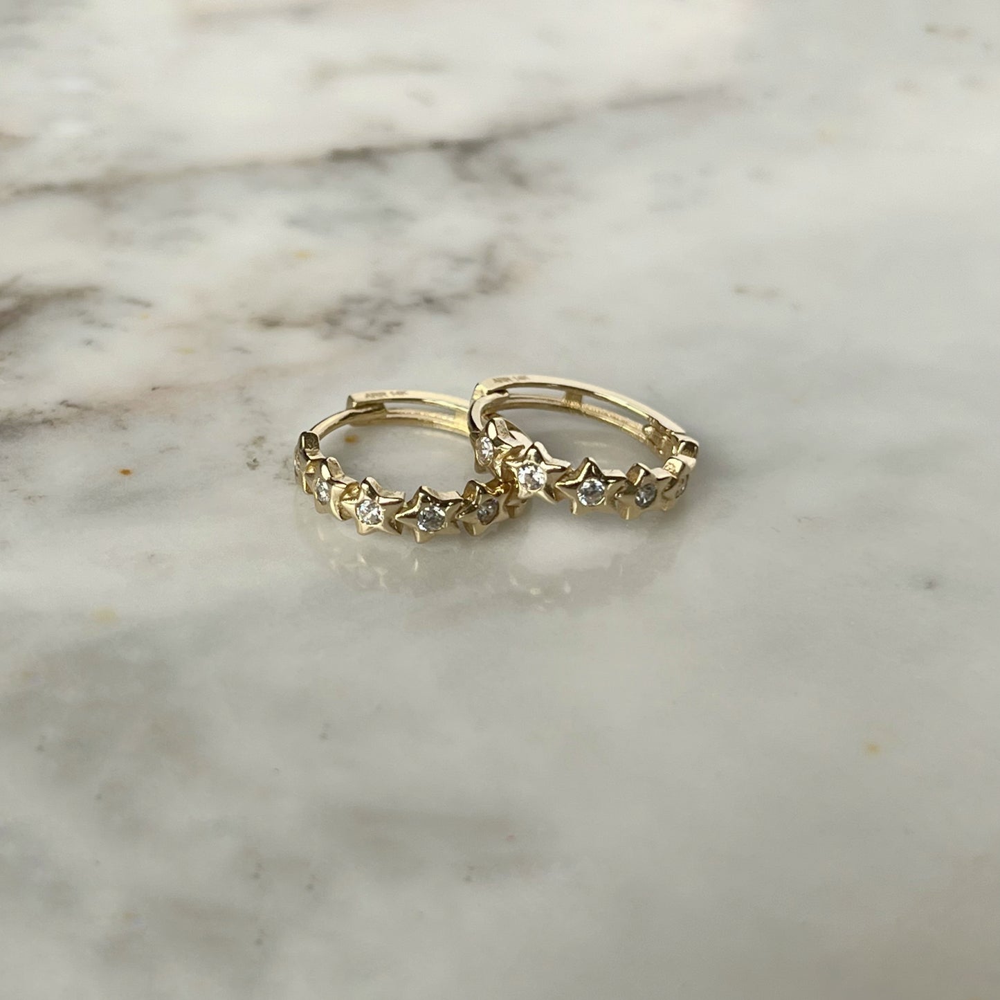 Argollas mini con circonitas blancas de estrellas en oro de 14k