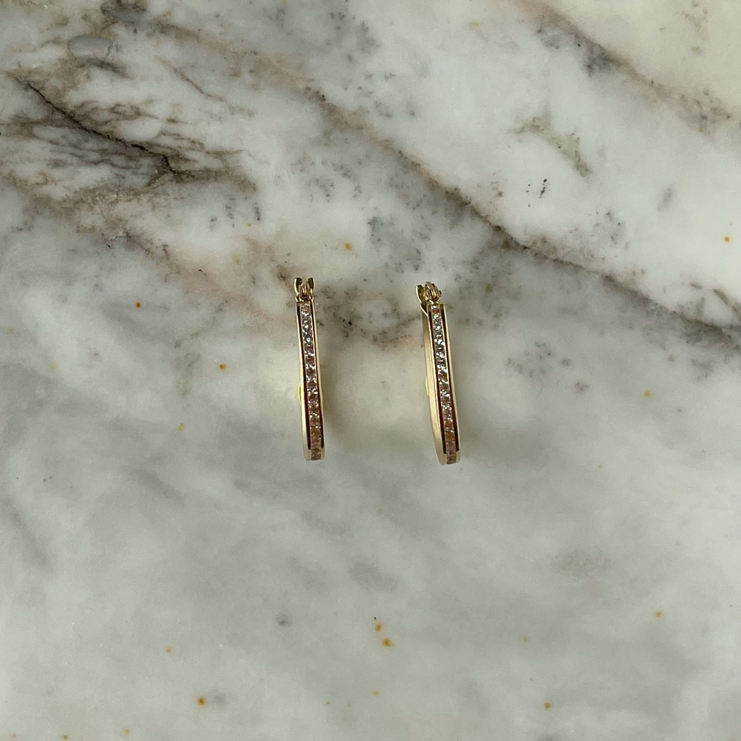 Argollas ovaladas con circonitas en oro amarillo 14k