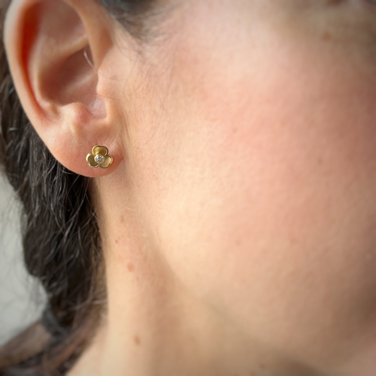 Aretes flor 3D de tres pétalos con circonita en el centro y tope ortopédico en oro amarillo de 14k