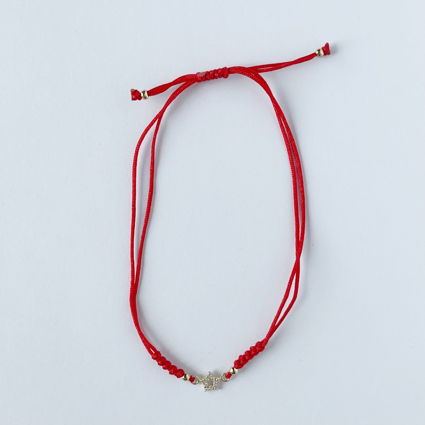 Pulsera cordón rojo estrella vacía en oro de 14K