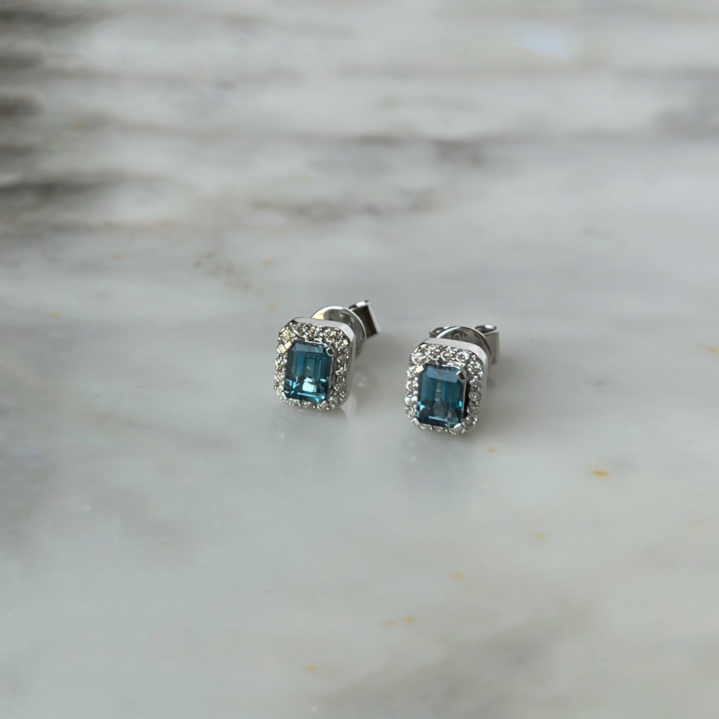 Aretes en oro blanco 10k con topacio London blue rectangular y halo de diamantes 0.10ctw