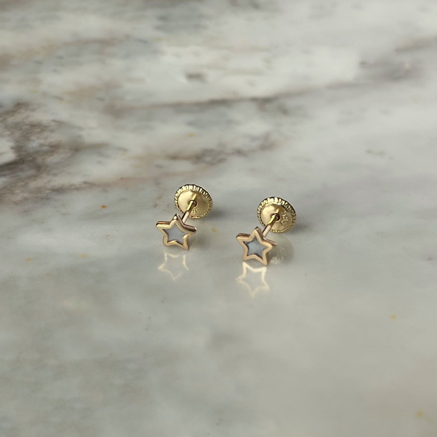Aretes estrella con centro de madre perla y filo de oro amarillo de 14k