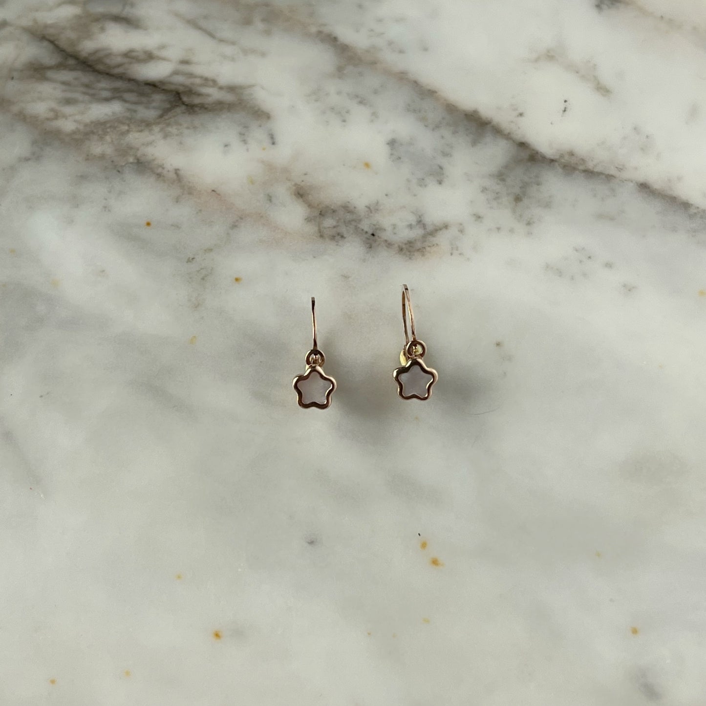 Arete gancho frances con florcita en madre perla en oro rosado de 14k