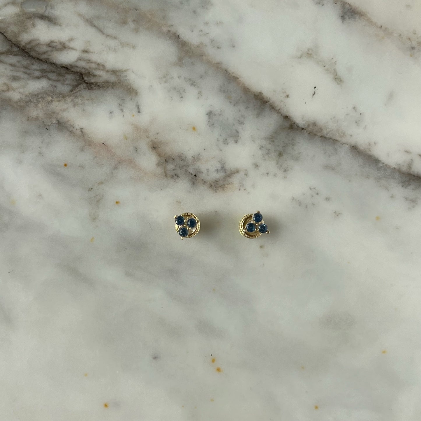 Aretes tres circonitas color celeste de 3mm en forma de triángulo en oro amarillo de 14k con tope ortopédico
