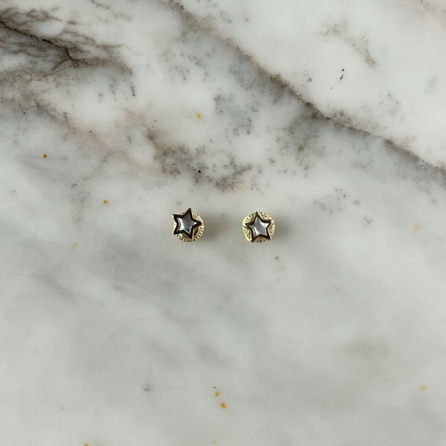 Aretes estrella con centro de madre perla y filo de oro amarillo de 14k