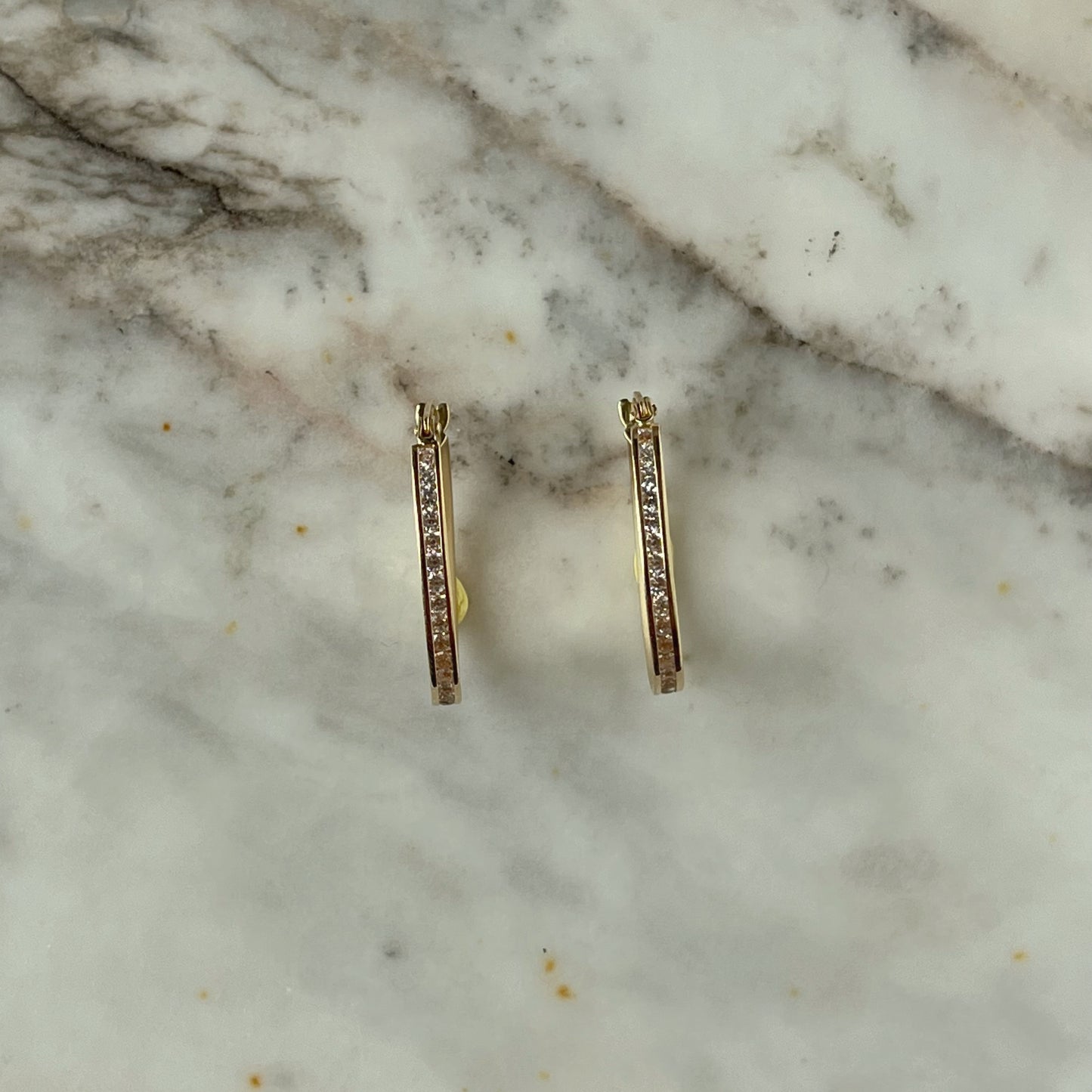 Argollas ovaladas con circonitas en oro amarillo 14k