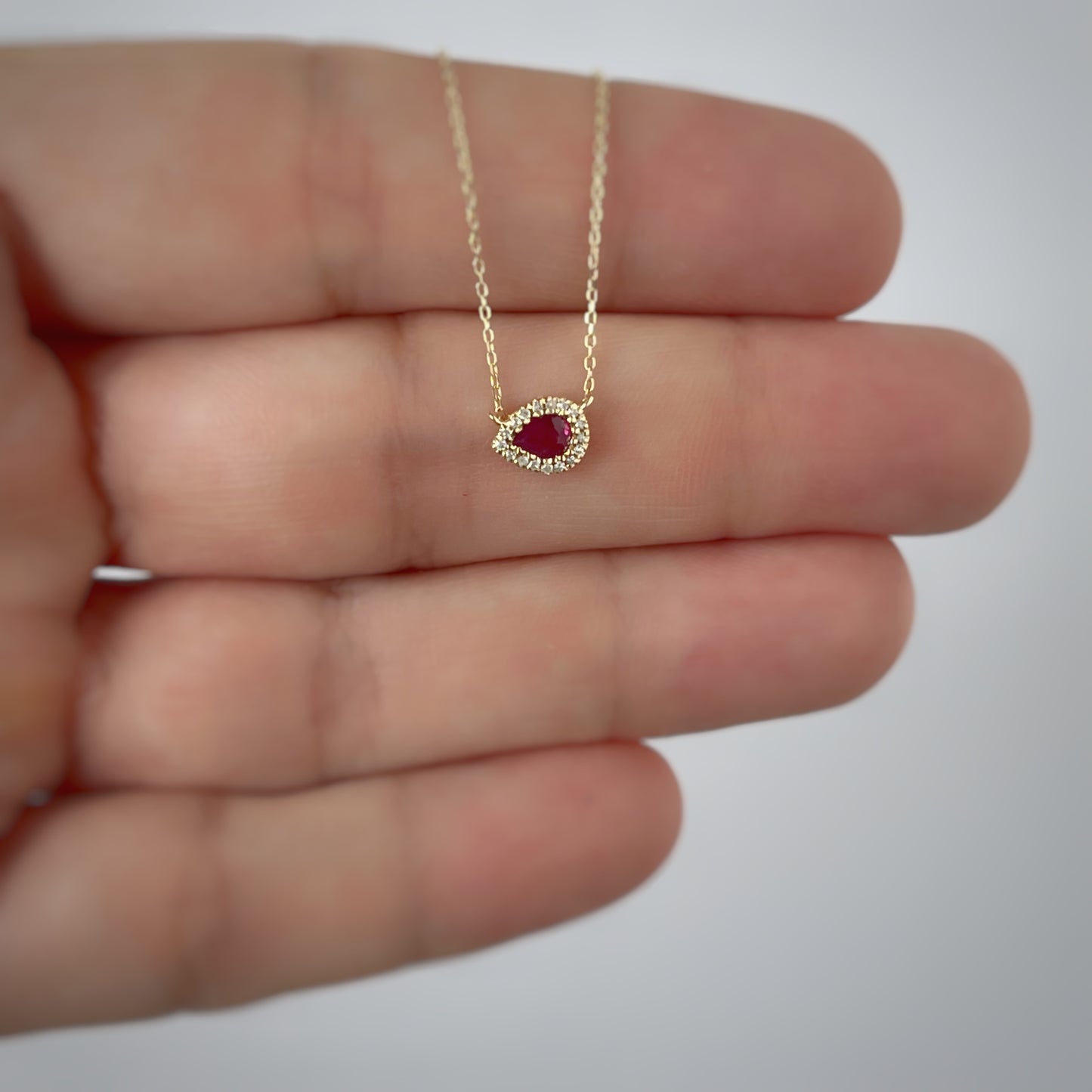 Collar en oro amarillo 14k con gota de rubí 0.17ctw y halo de diamantes 0.04ctw