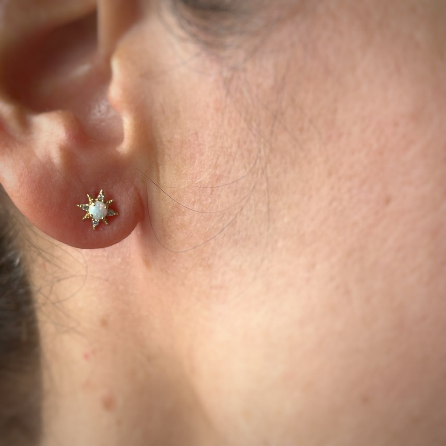 Arete piercing single de estrella polar con opalo blanco y circonitas en oro amarillo de 14k