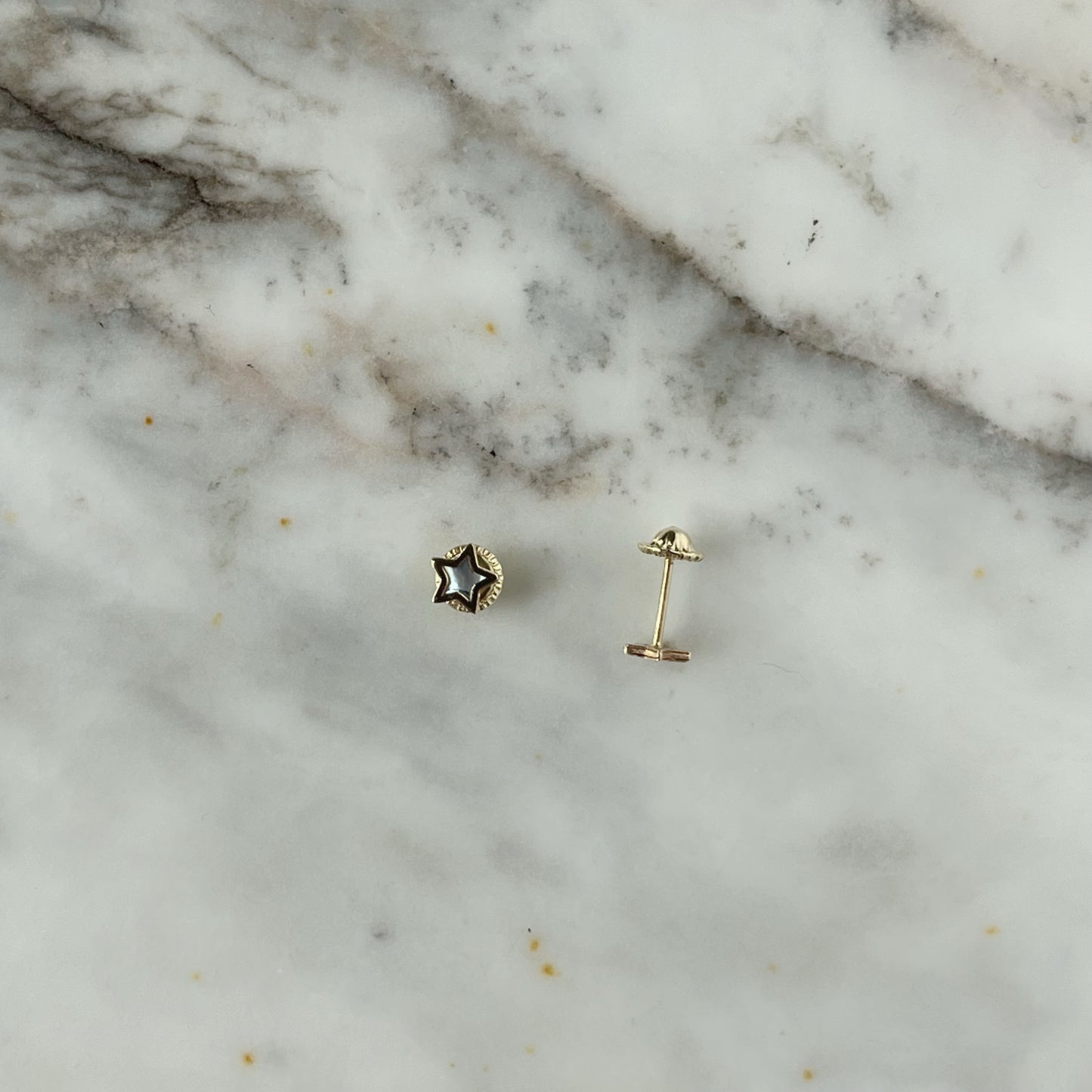 Aretes estrella con centro de madre perla y filo de oro amarillo de 14k