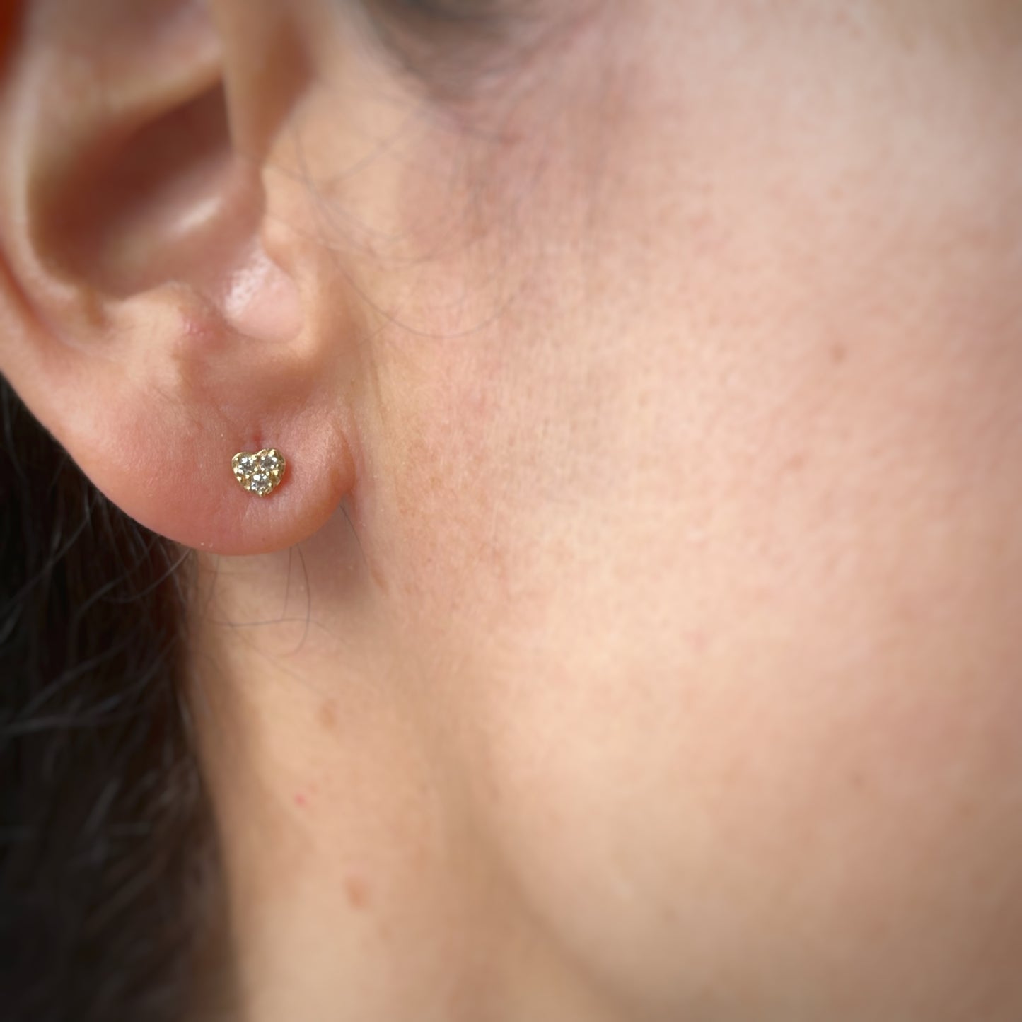 Aretes en forma de corazón con tres circonitas blancas en oro de 14k con tope ortopédico