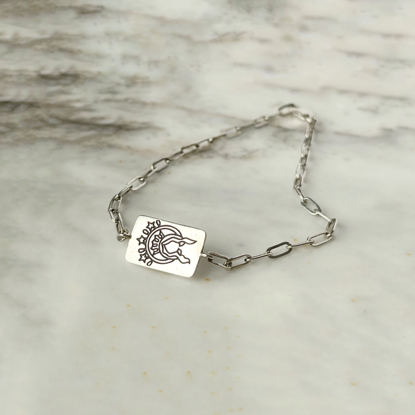 Pulsera paperclip con escapulario rectangular en plata
