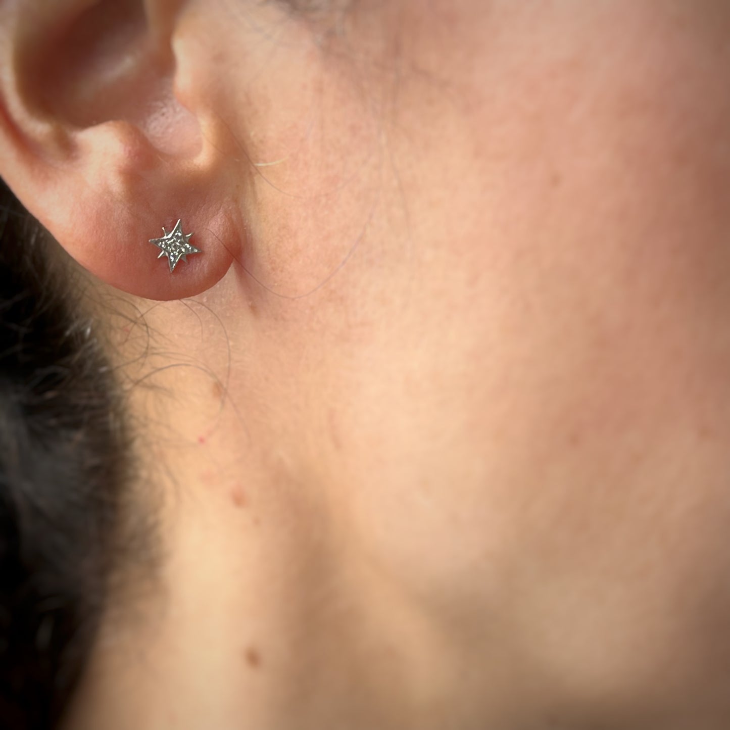 Arete single estrella polar con circonitas en oro blanco de 14k