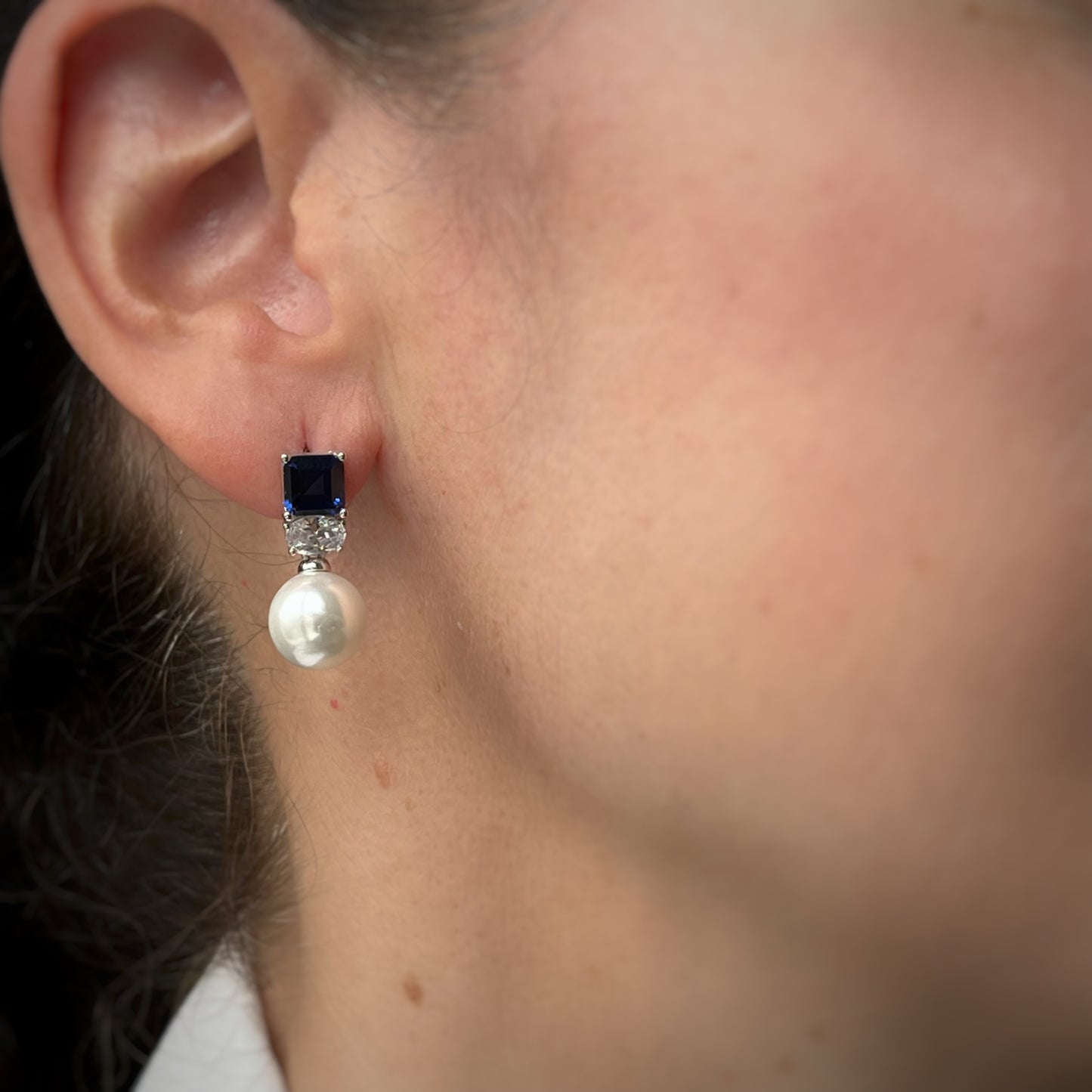 Aretes en plata con baño de platino con circonita azul y perla de cristal