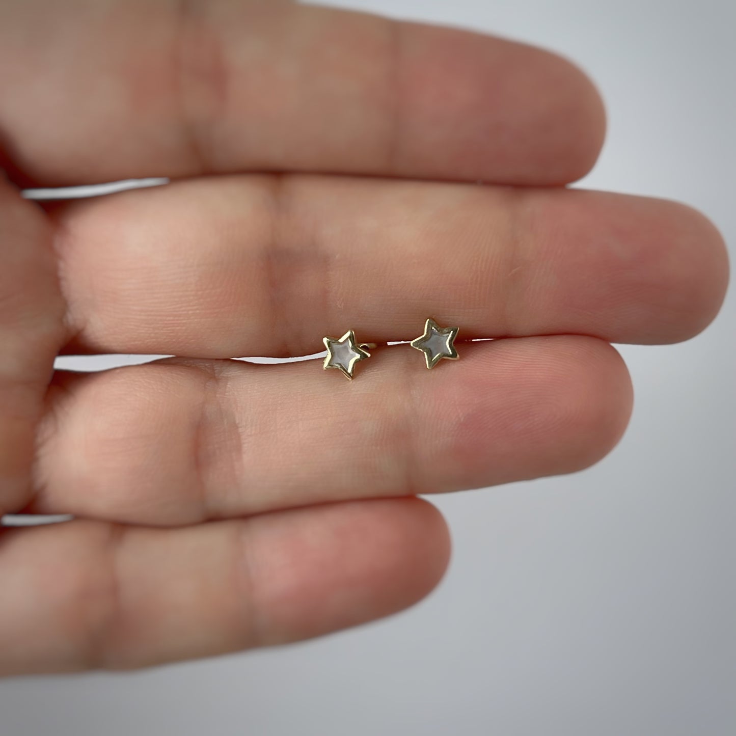 Aretes estrella con centro de madre perla y filo de oro amarillo de 14k